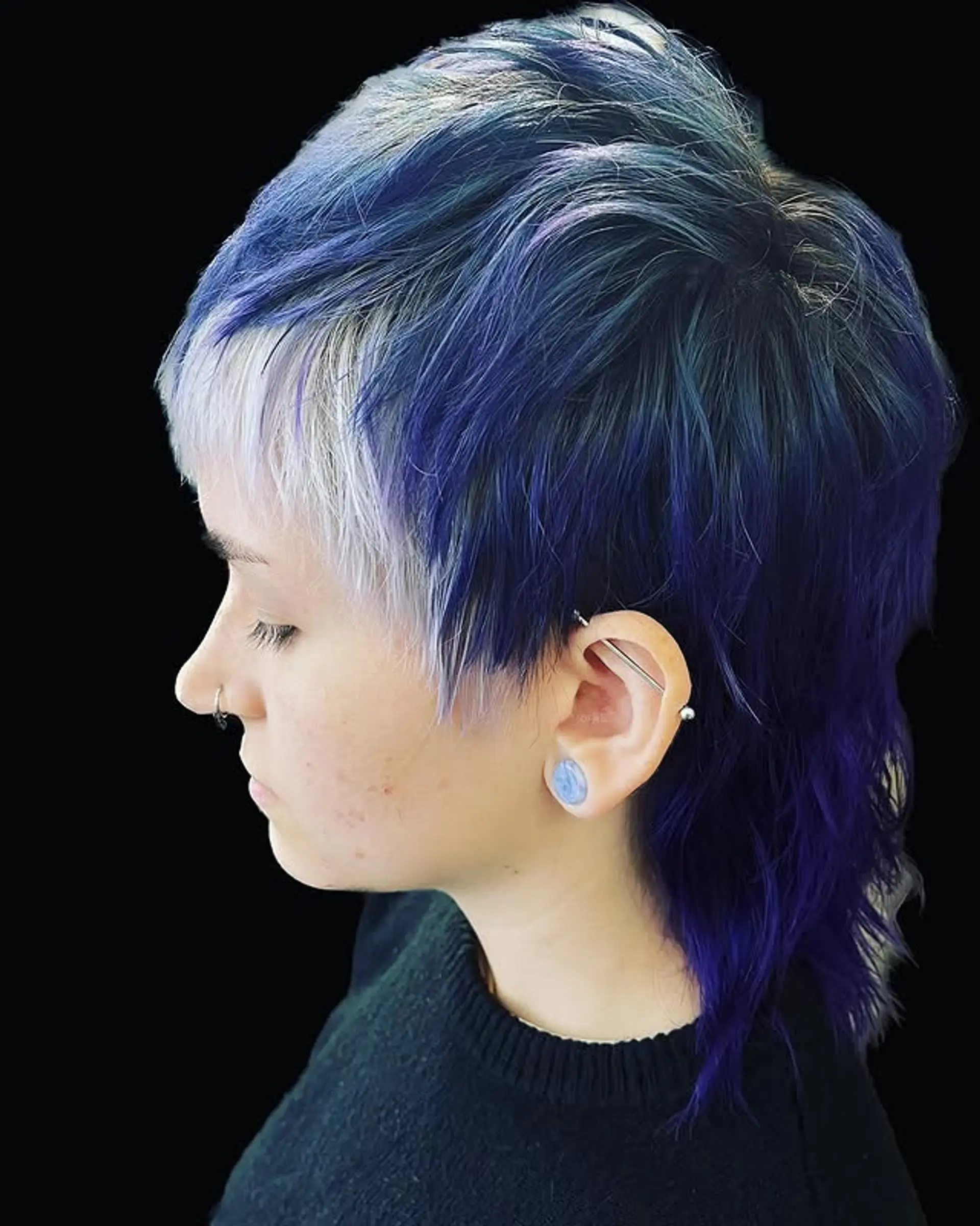 A trendy mullet with short, choppy layers and contrasting pastel blue and silver/white bleached bangs. 1