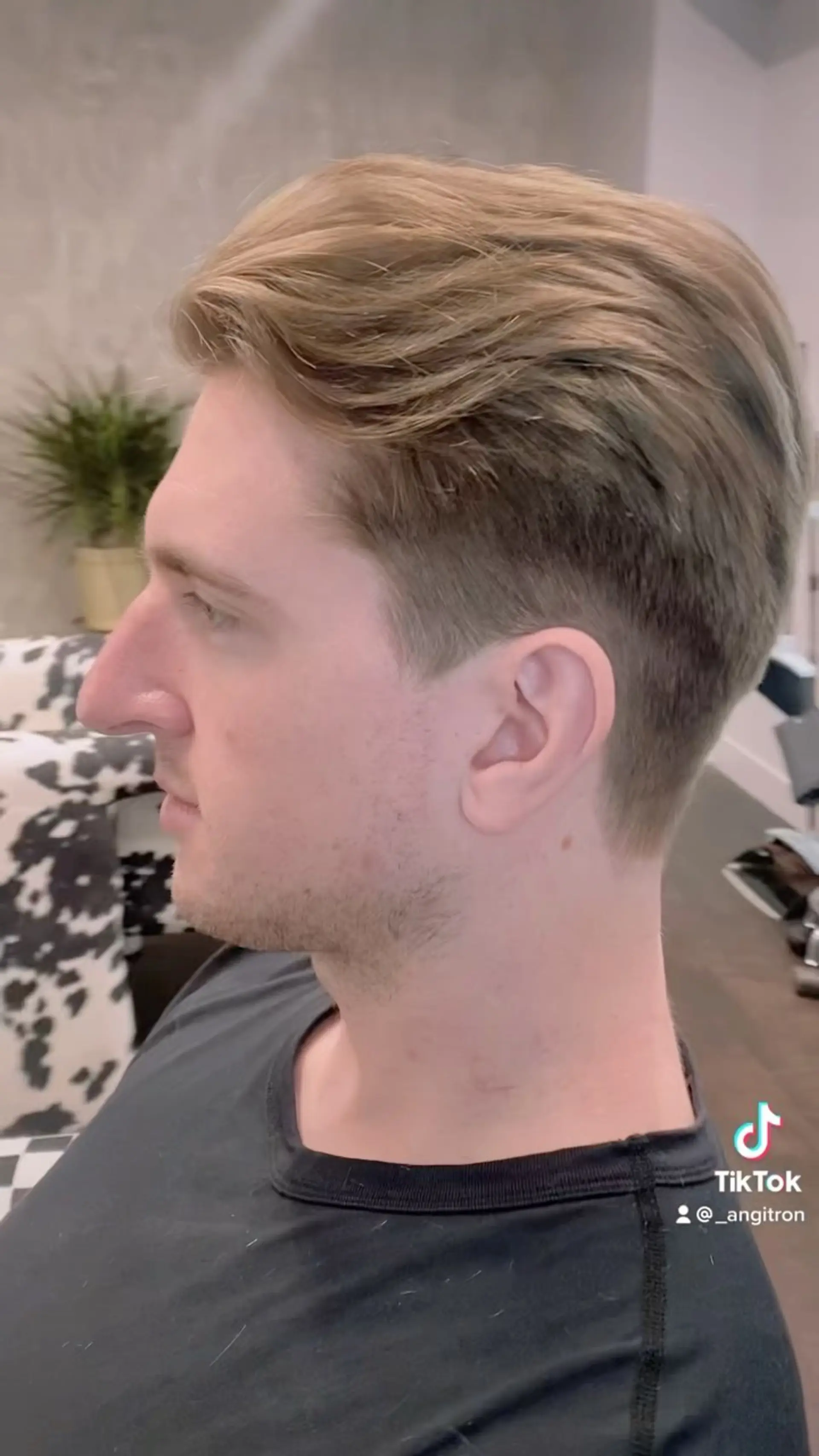 A men's haircut with neat, tapered sides blended into a longer, swept-back textured top. 1