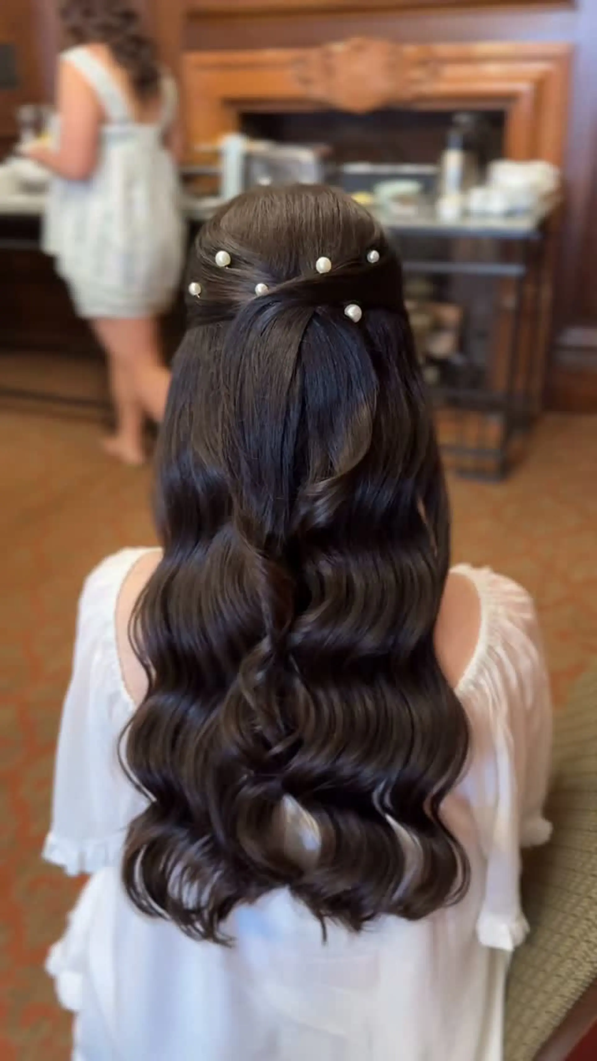 Half-up half-down hairstyle featuring structured, glossy waves adorned with elegant pearl accent pins. 1