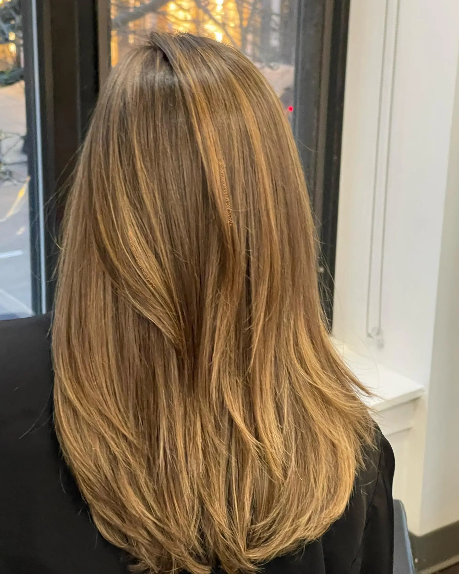 Long layered hair featuring seamless warm honey blonde foilayage highlights with a soft blowout finish. 1