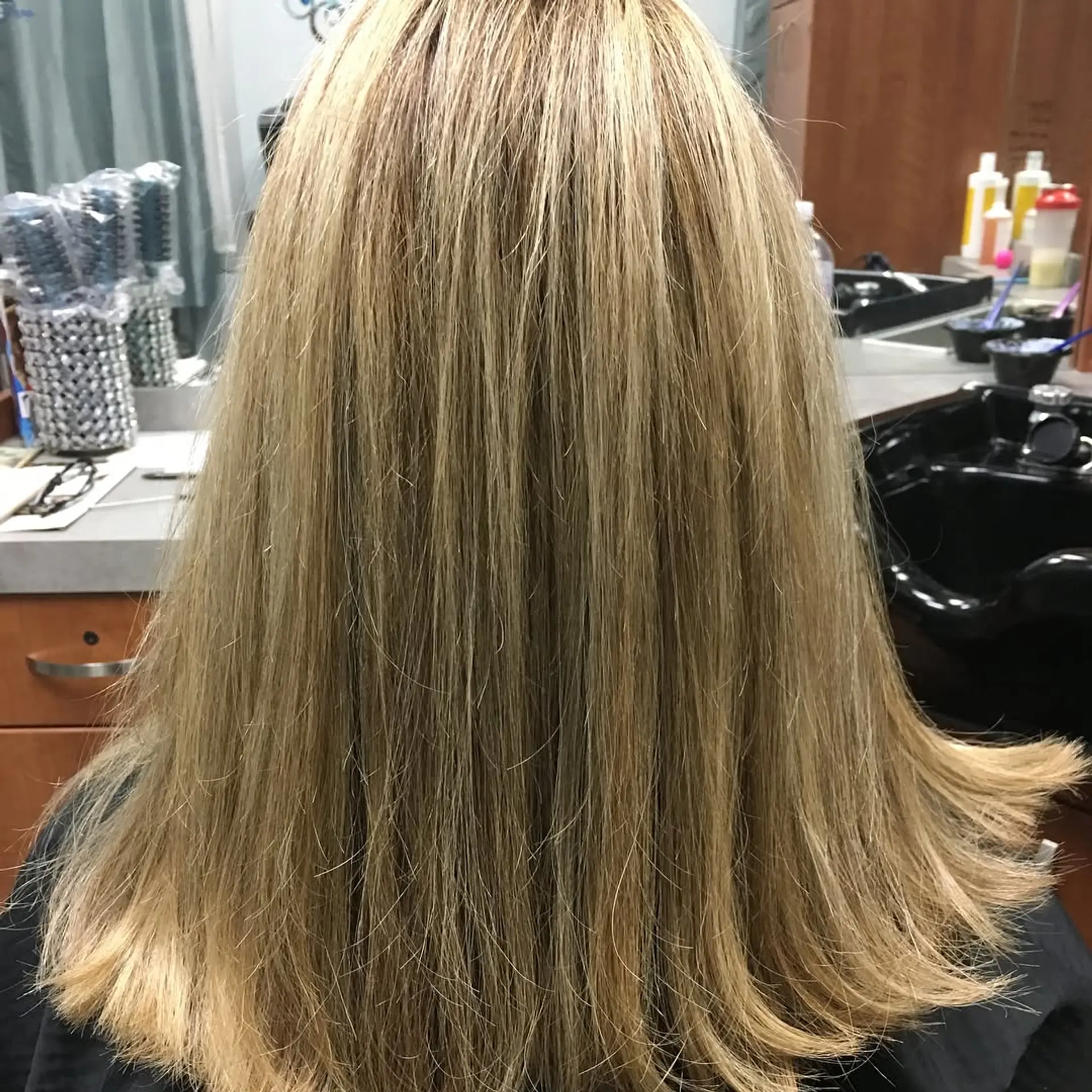 A smooth, medium-length straight blonde style with subtle dimension and outward flicked ends. 1