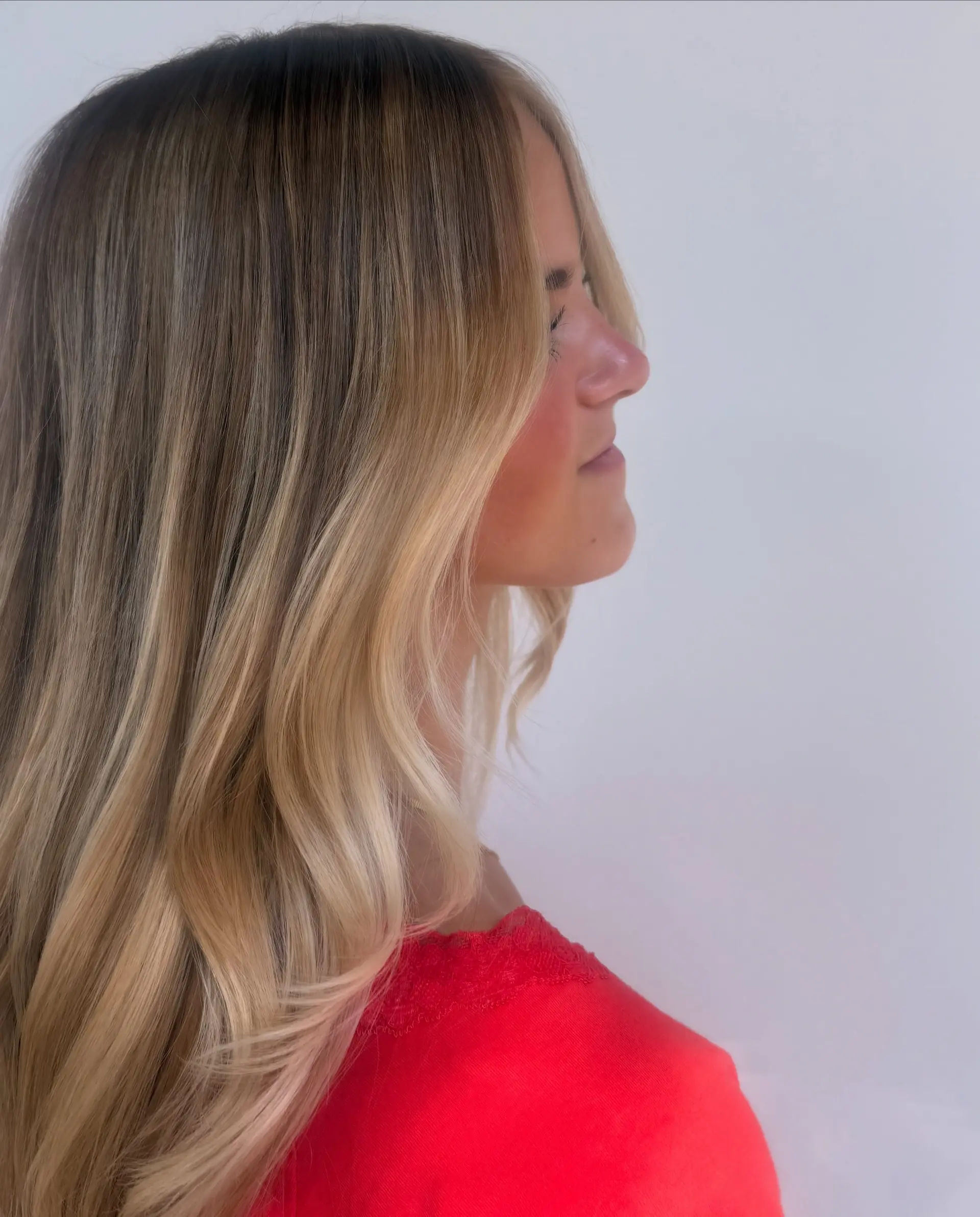 Long warm honey blonde balayage with smooth texture and soft face-framing layers. 1
