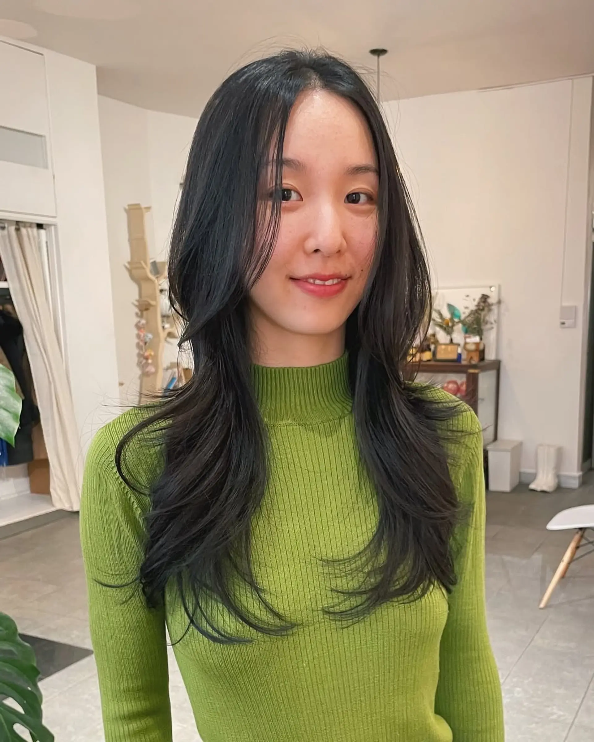 Features long, straight hair with curtain bangs and layered face-framing. 1