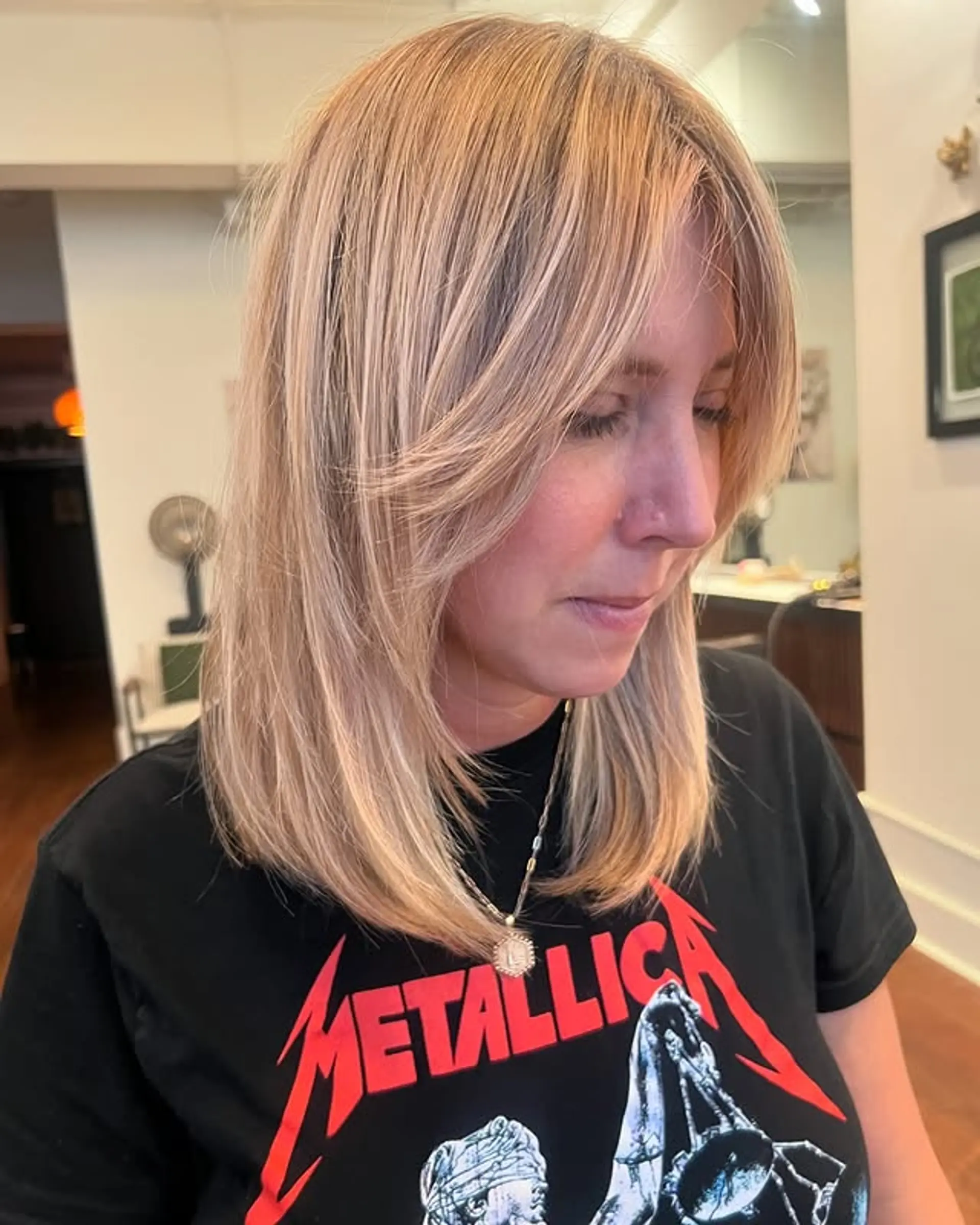 A layered medium-length haircut with face-framing layers and curtain bangs. 1