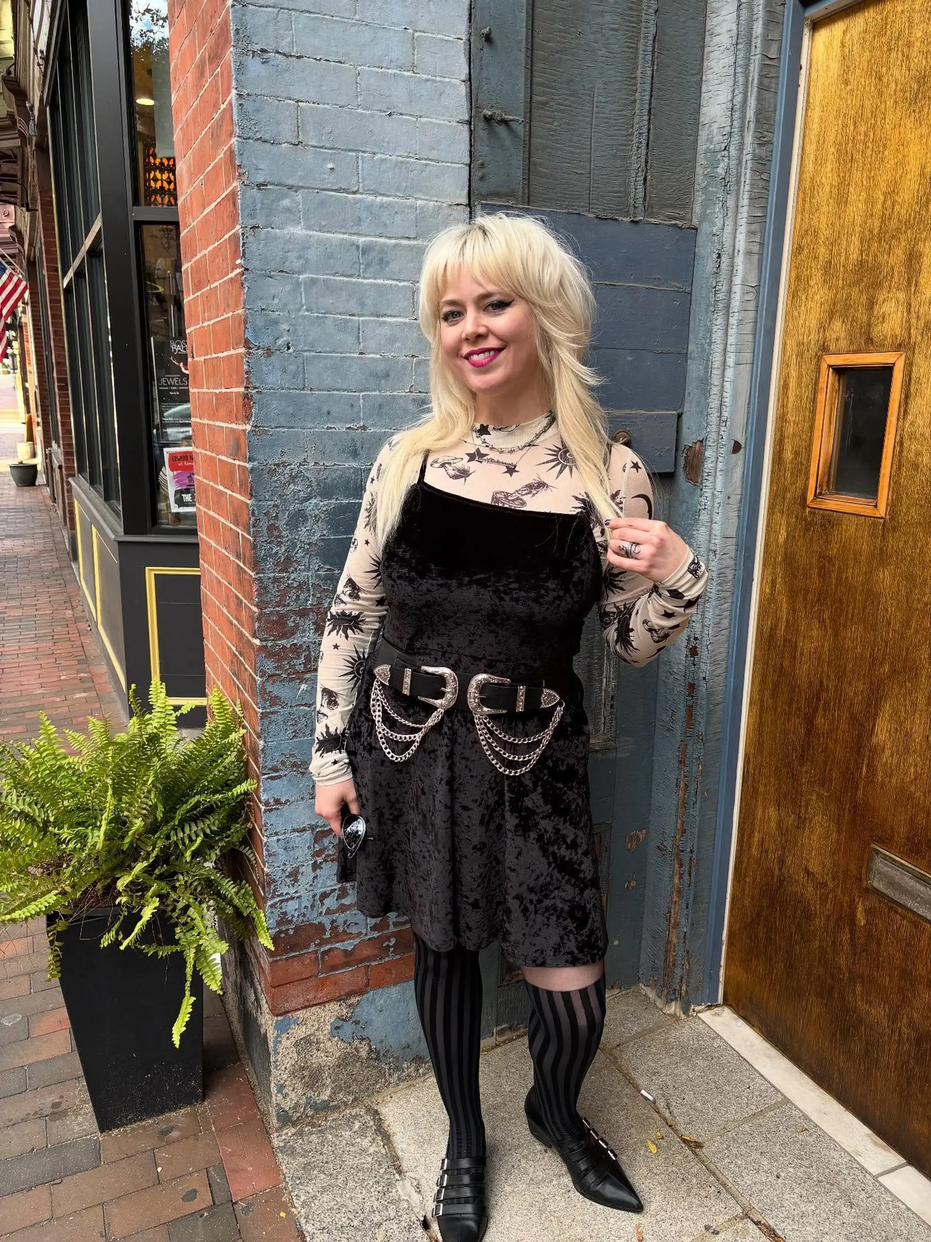 A retro-inspired bleach blonde shag mullet featuring wispy straight bangs, voluminous feathered crown layers, and textured face-framing lengths. 1