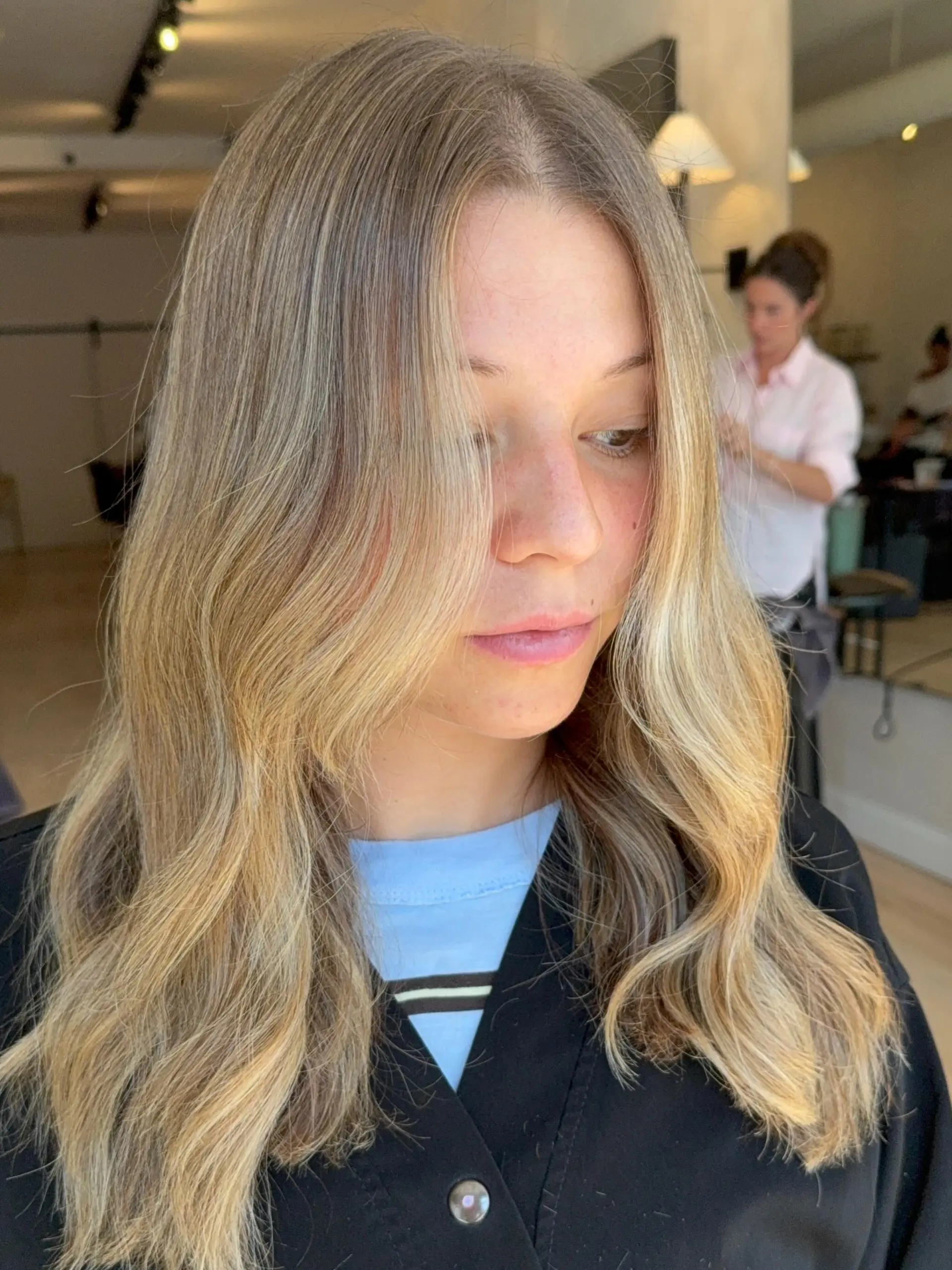 Long dimensional blonde hair styled into soft, loose waves with face-framing layers. 1