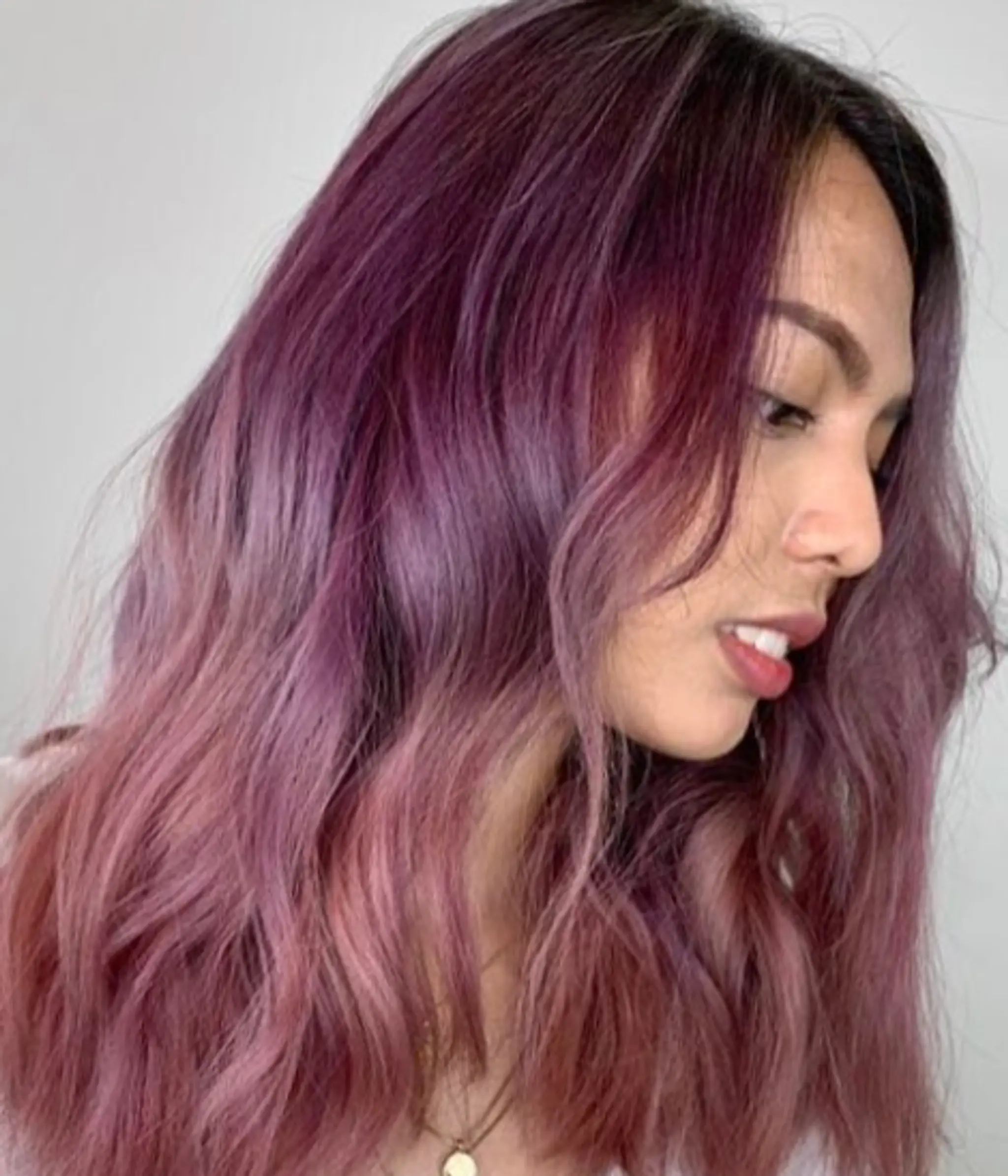 Medium-length hair with a soft, wavy texture, colored in vibrant shades of purple and lavender, featuring a side part.
