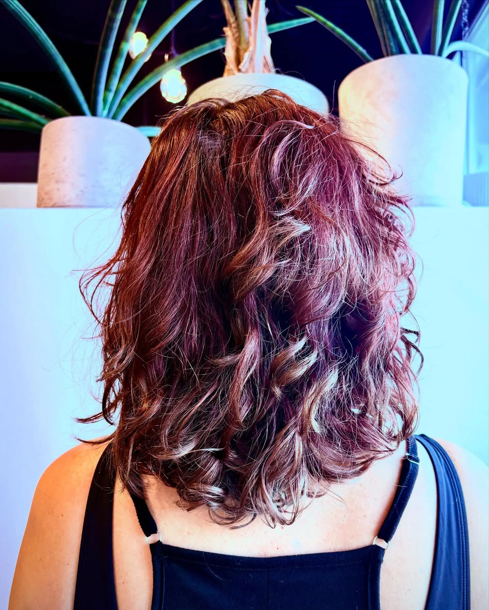 A medium-length layered cut designed to define and enhance natural curls with movement and volume. 1