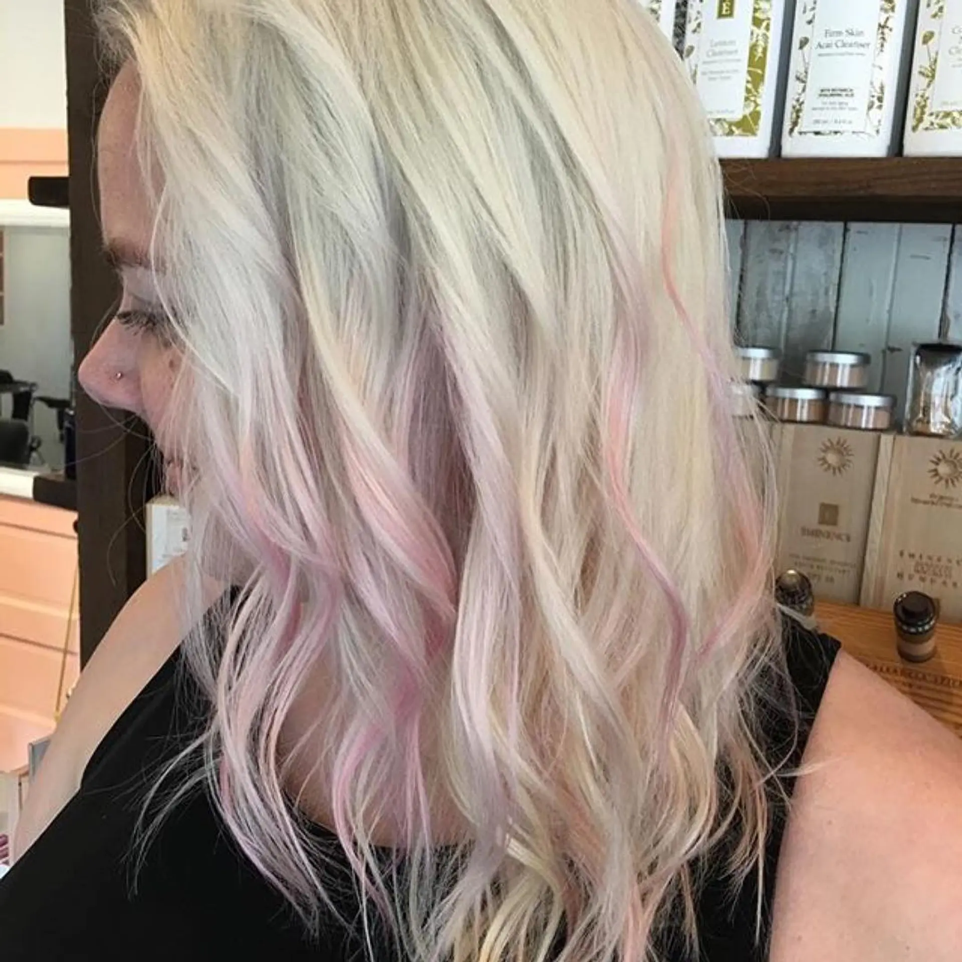 Medium-length wavy platinum blonde hair featuring delicate pastel pink accent pieces woven throughout. 1