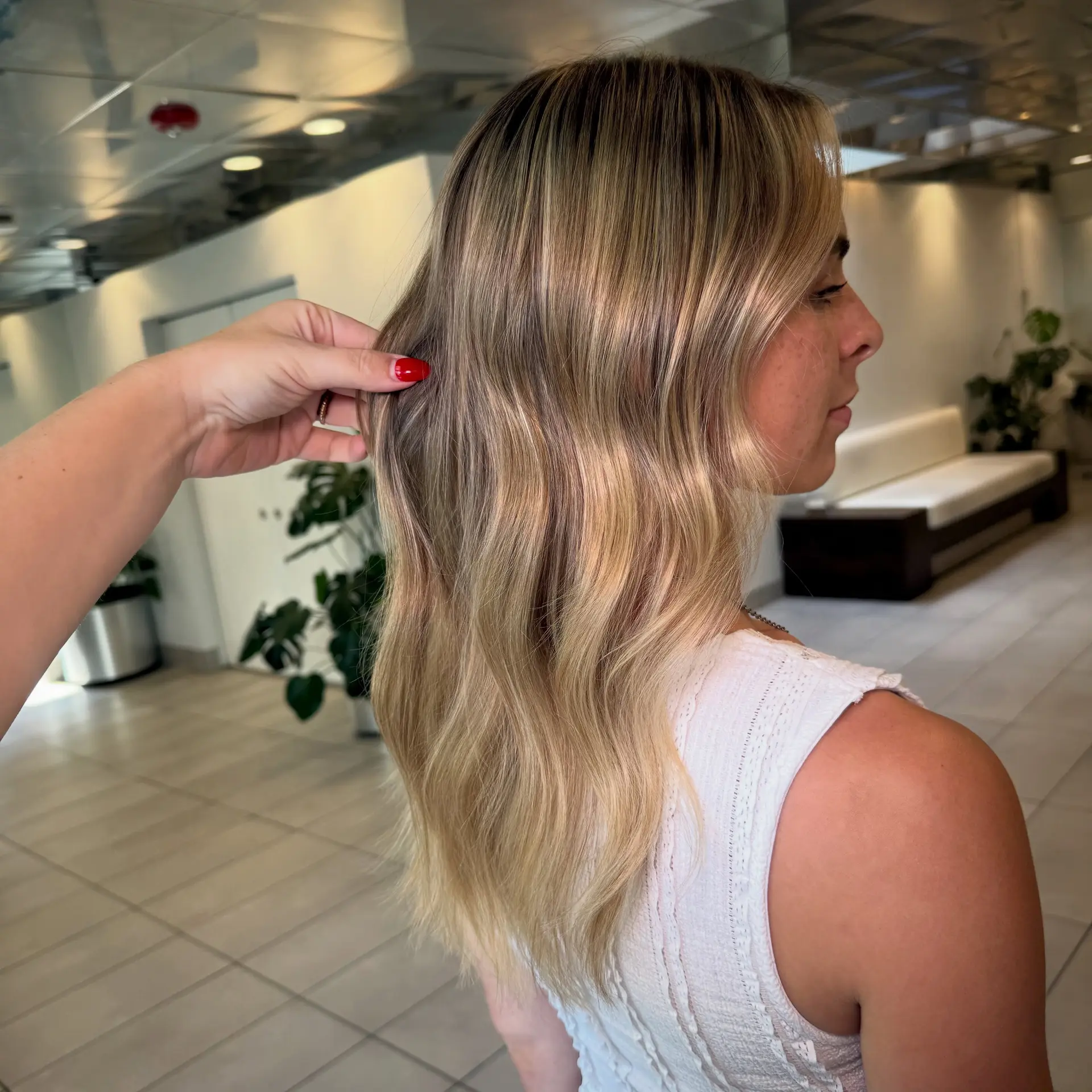 Dimensional warm blonde balayage with a seamless root transition, styled in soft loose waves. 1