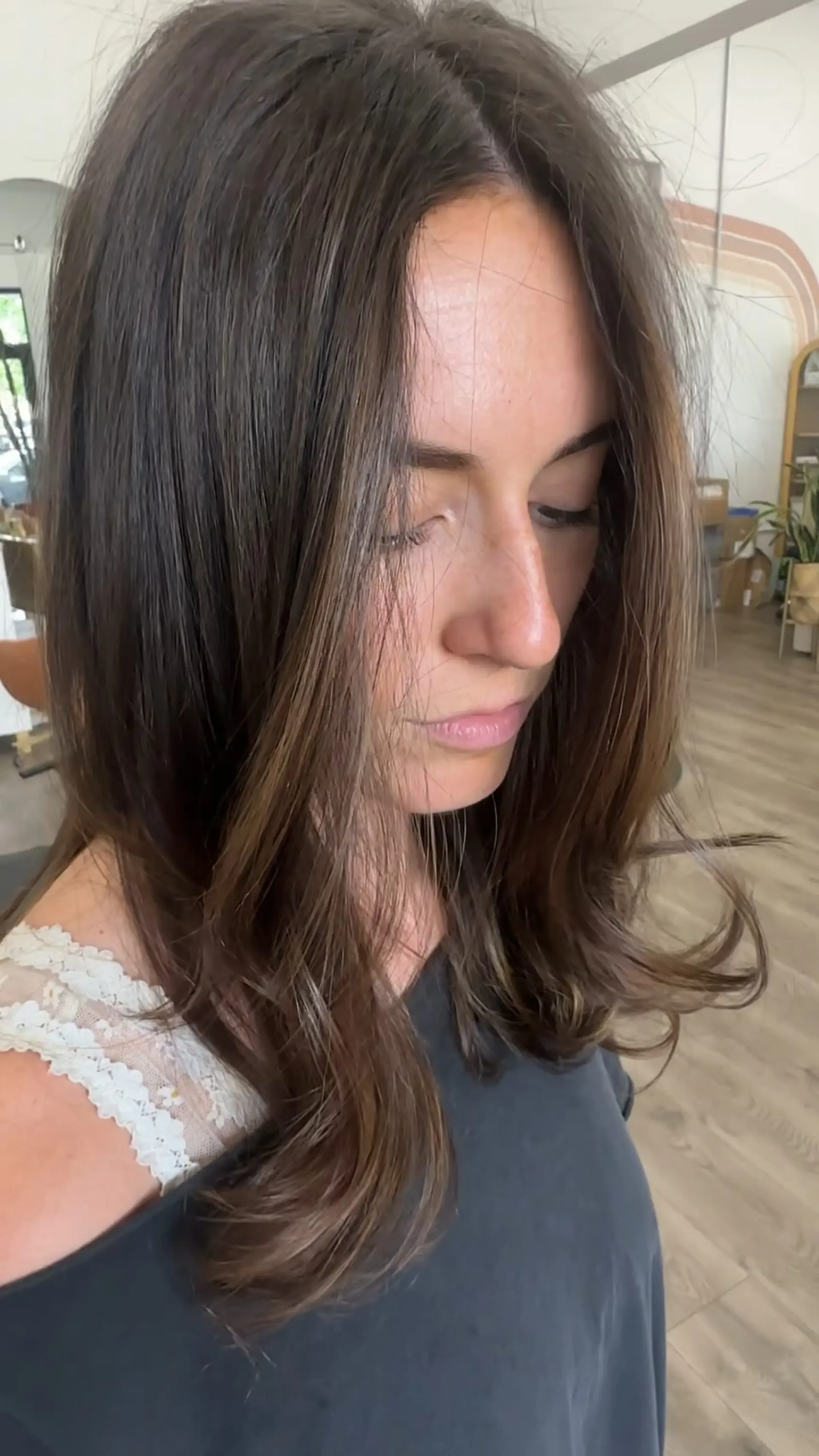 Medium-length rich brunette hair styled with soft, loose waves and gentle subtle highlights to break up monochromatic depth. 1