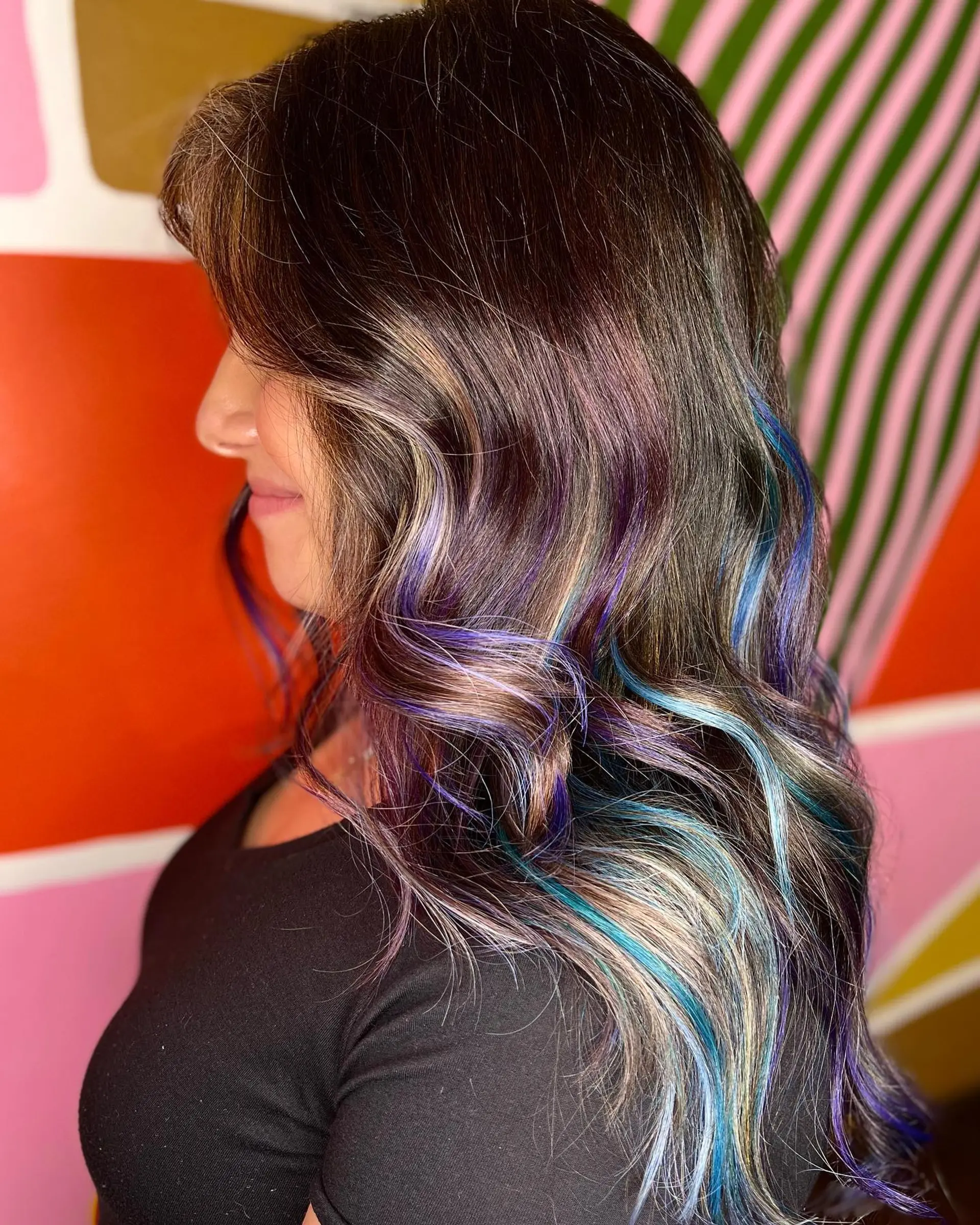 Long wavy dark hair featuring vibrant oil slick highlights in purple, blue, and teal tones. 1