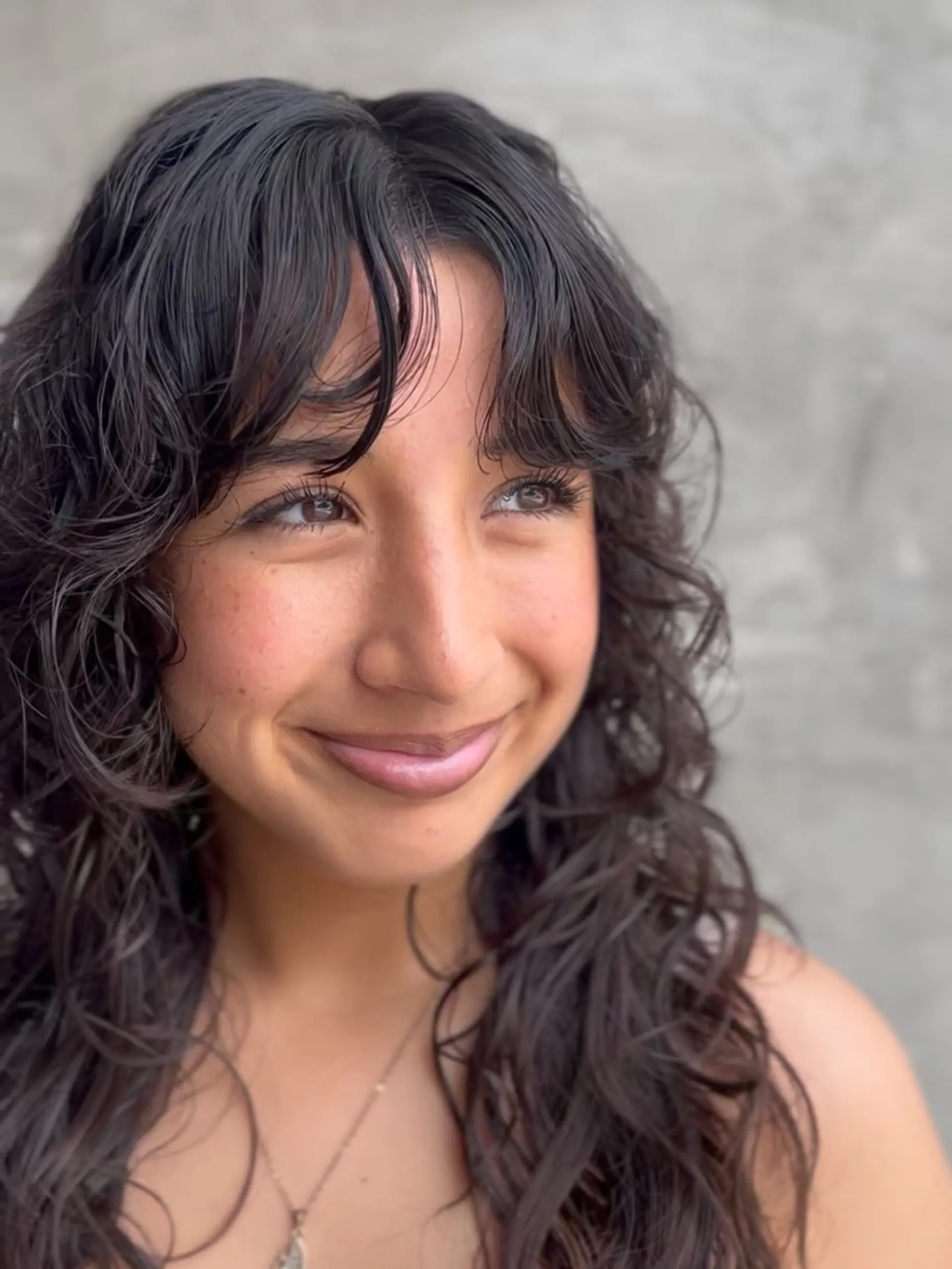 A textured curly wolf cut with soft, face-framing fringe and defined natural curls. 1