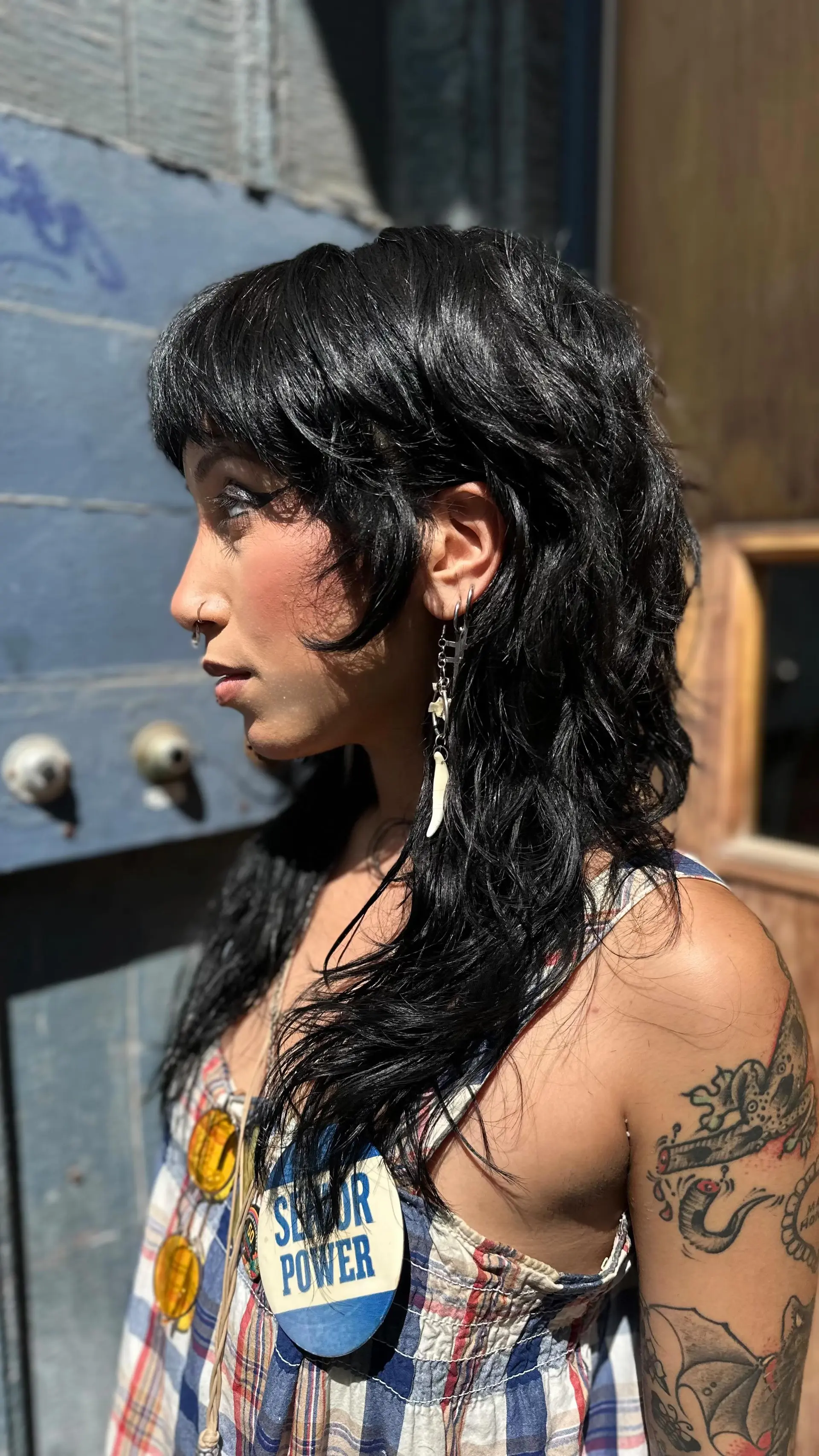 A textured black shag mullet haircut featuring layered crown volume, choppy micro bangs, and piecey face-framing tendrils. 1
