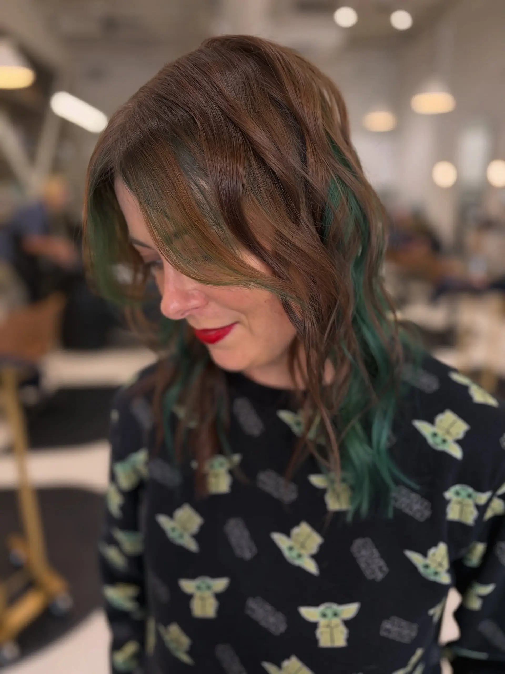Shoulder-length textured brunette waves featuring vibrant forest green peekaboo color underneath. 1