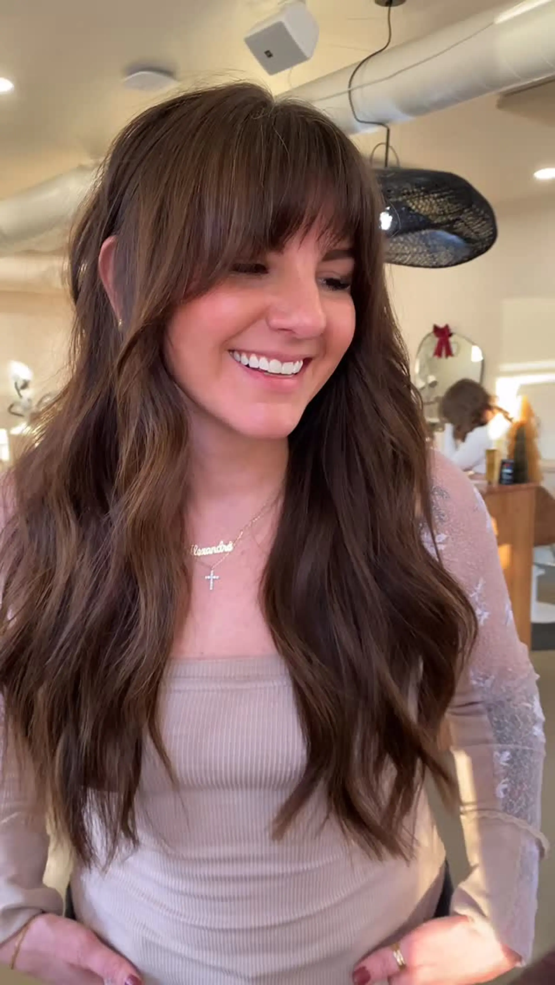 Long chocolate brown hair styled with loose natural waves and full, eyebrow-grazing bangs. 1