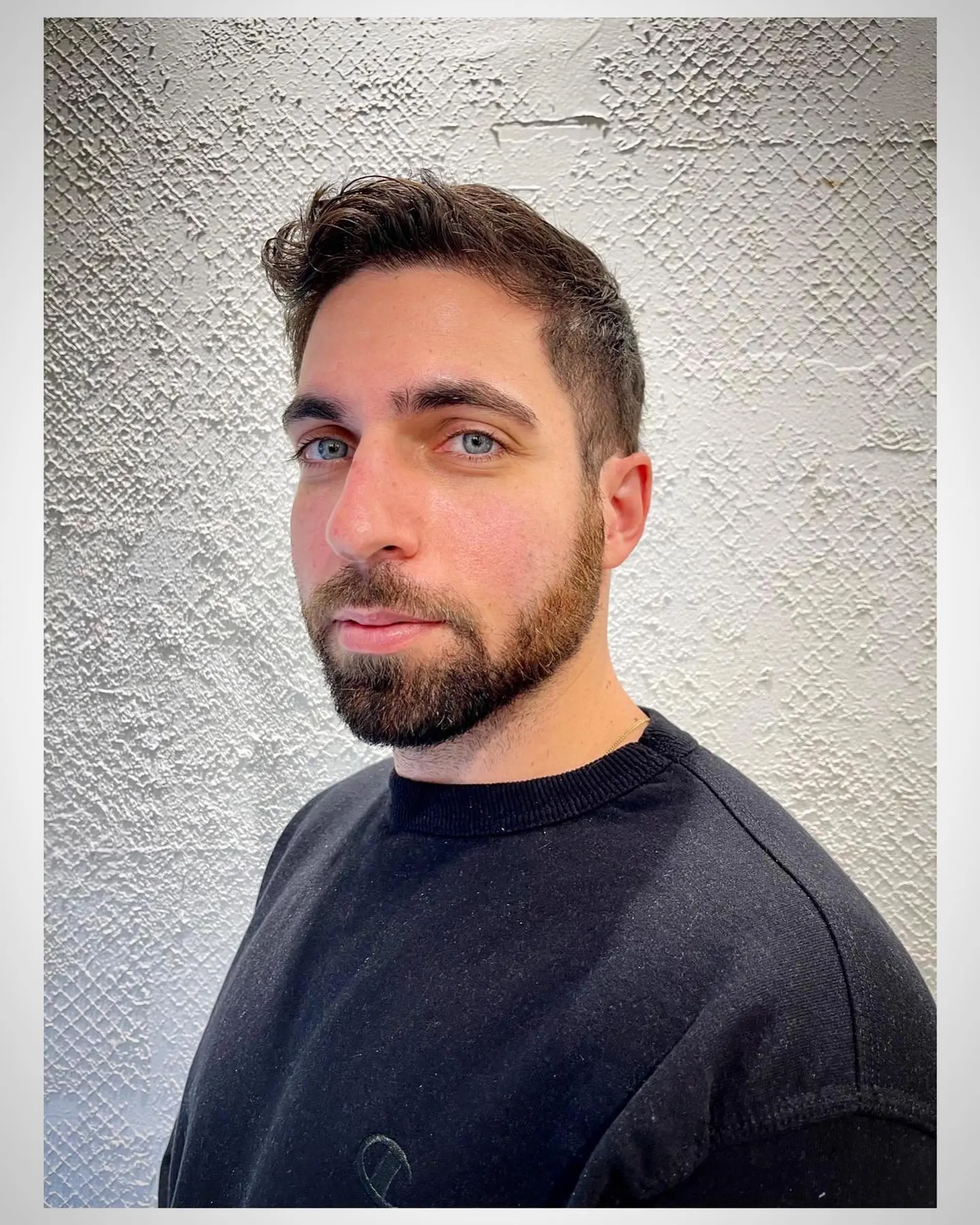 A clean short men's cut with neatly tapered sides and textured length on top styled upward and back. 1