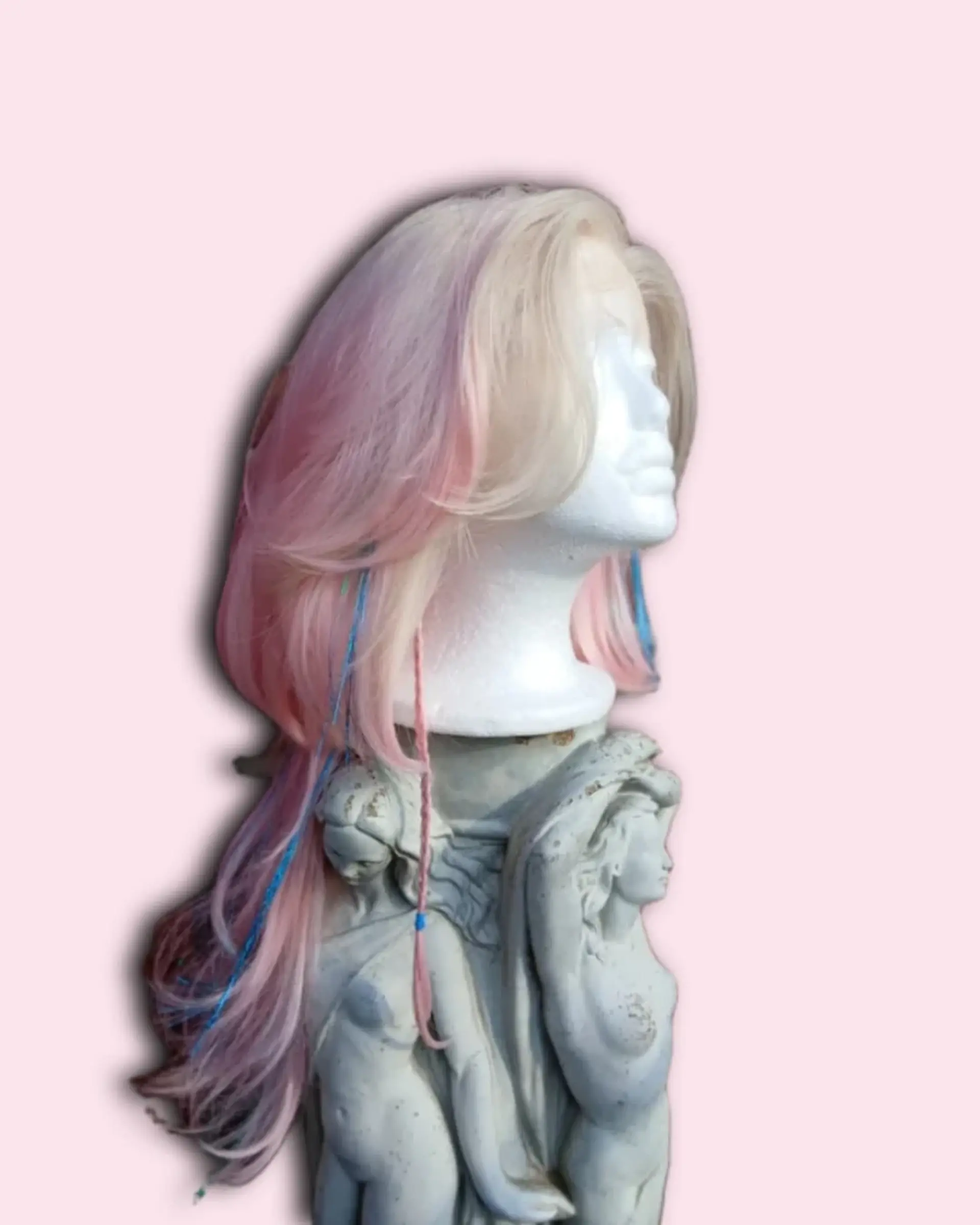 Long layered pastel wig with feathered face-framing curtain bangs, subtle micro-braids, and tinsel accents. 1