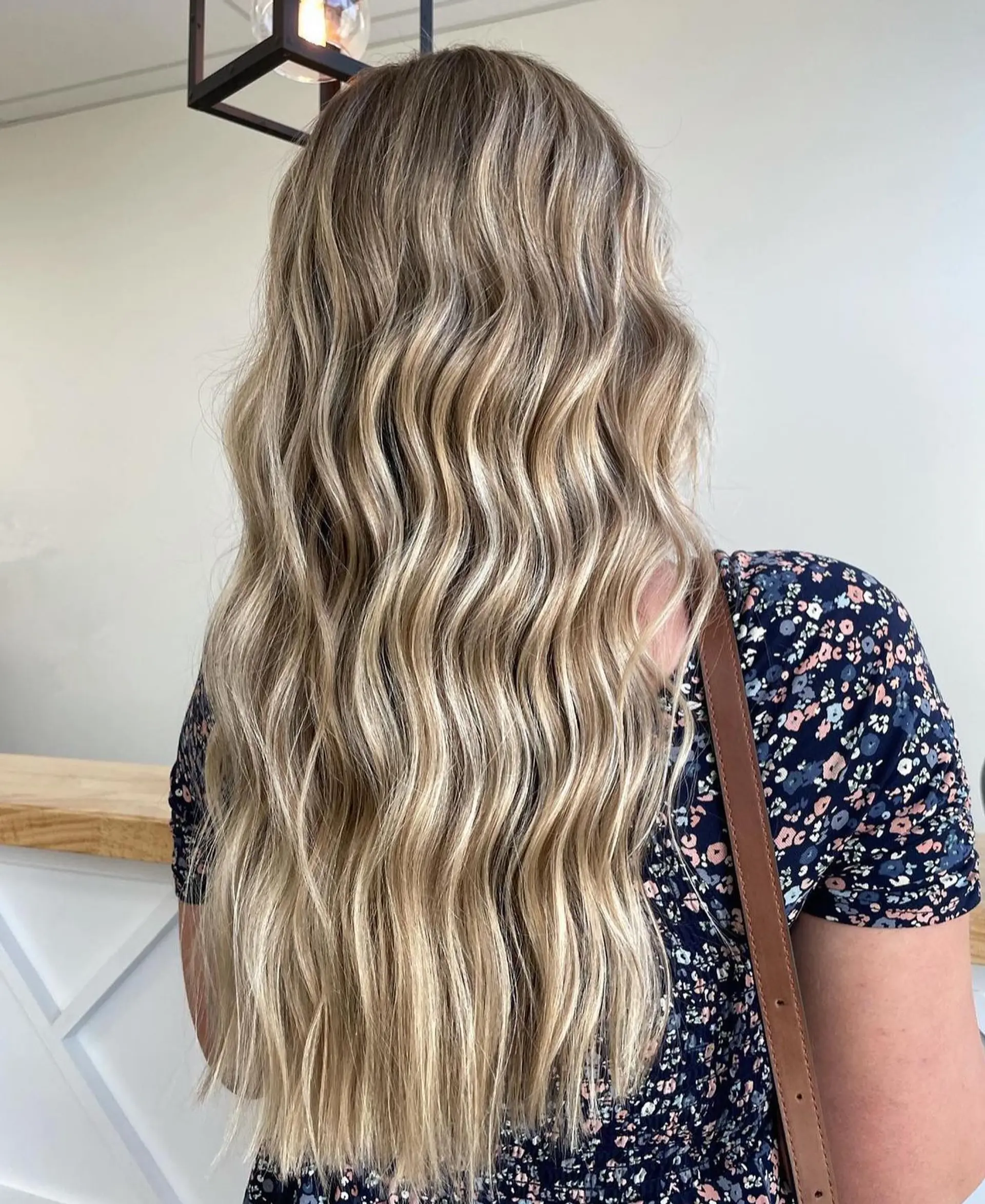 Long, flowing waves styled with a multi-tonal vanilla and honey blonde balayage over a light brown base. 1