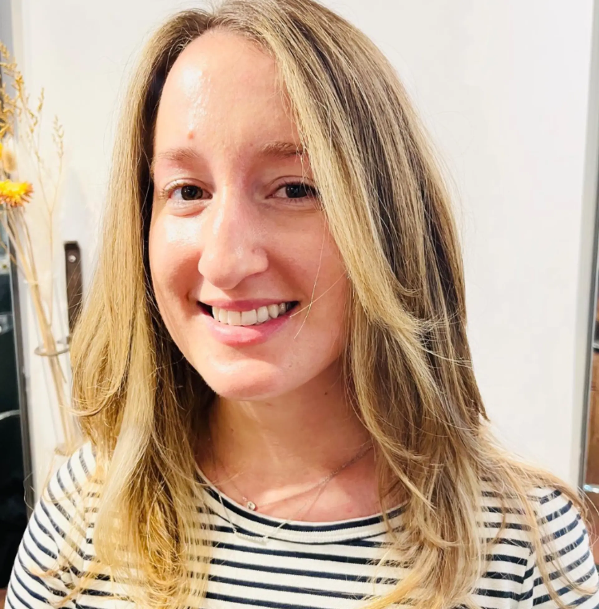 A layered, medium-length hairstyle featuring soft, beachy waves and blonde balayage highlights. 1