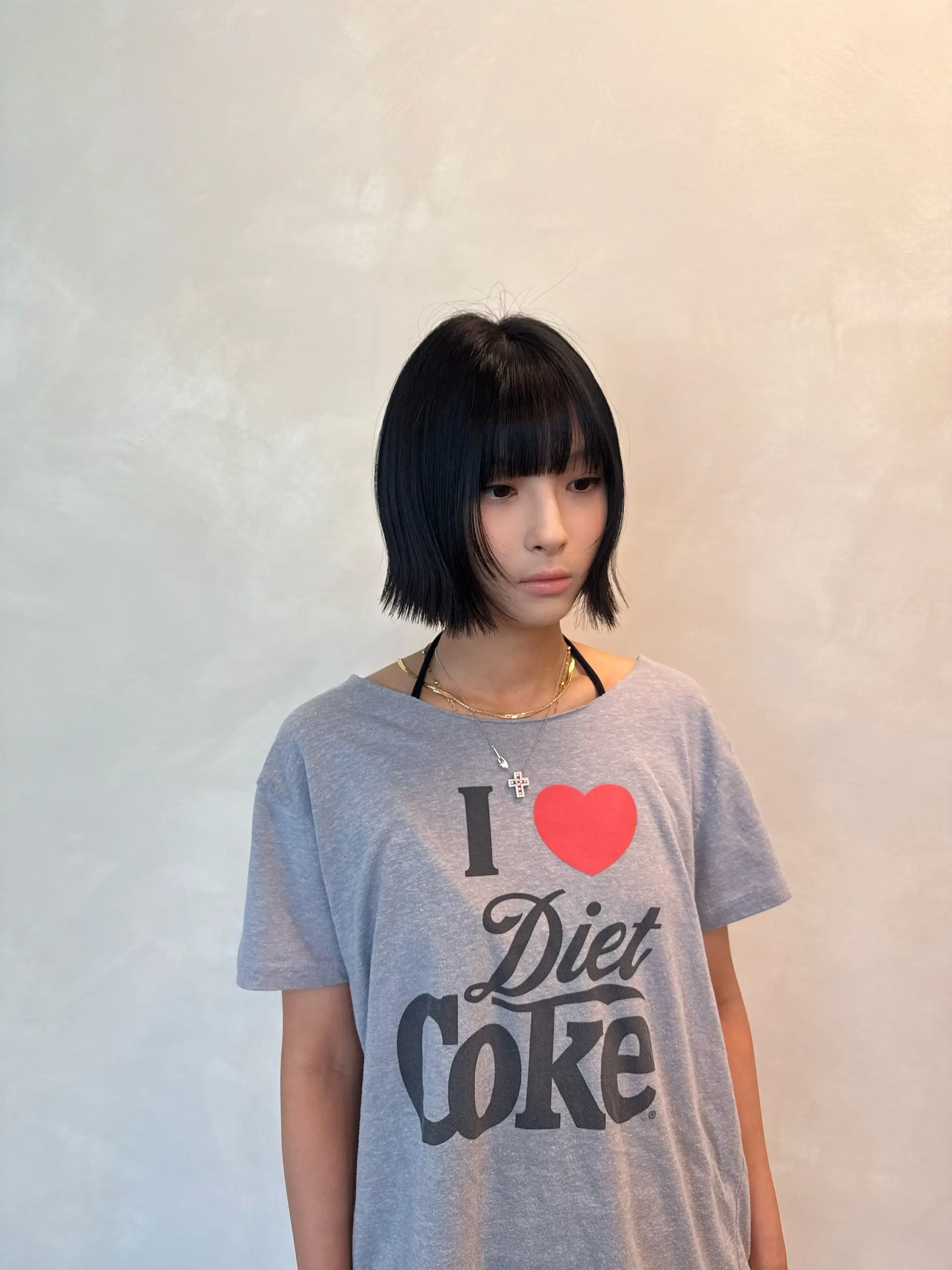 A sleek, chin-length blunt bob featuring straight-across full bangs and softly textured ends. 1