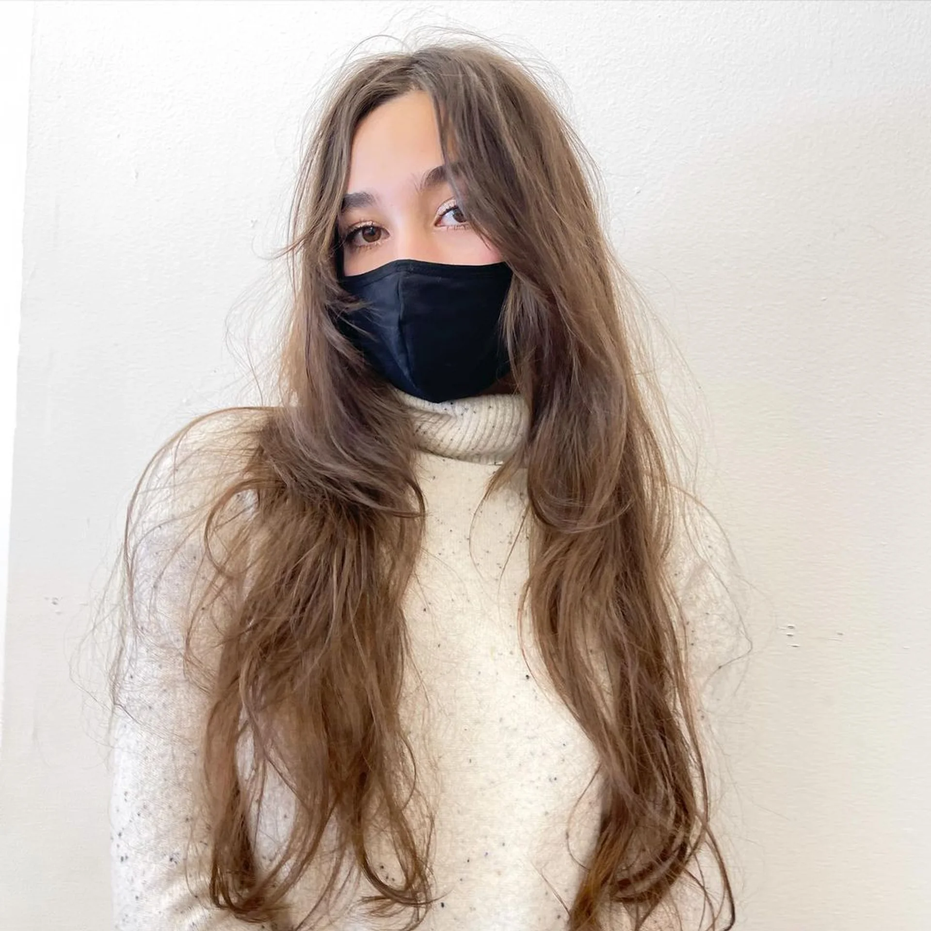 A woman with long wavy blonde hair featuring soft, voluminous ghost layers and face-framing pieces, a key 2025 NYC hair trend for fine hair. - Preview 1