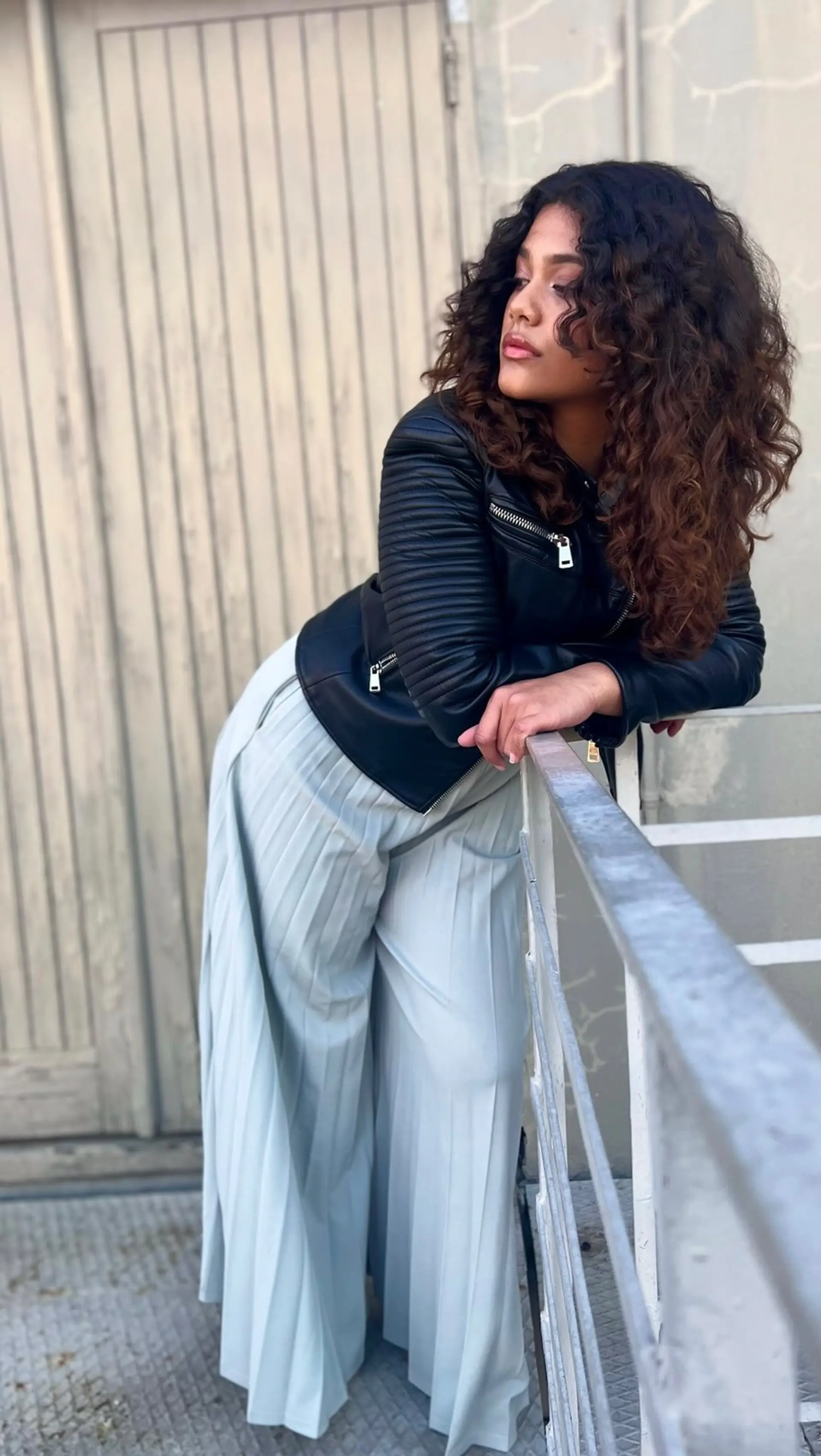 Voluminous long curly hair cut with face-framing layers and rich brown dimension. 1