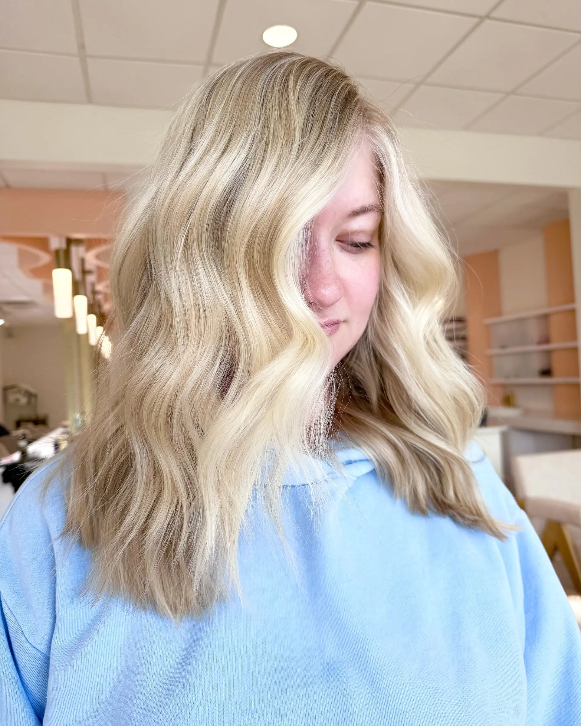 Medium-length buttery blonde hair styled into soft, flowing textured waves. 1