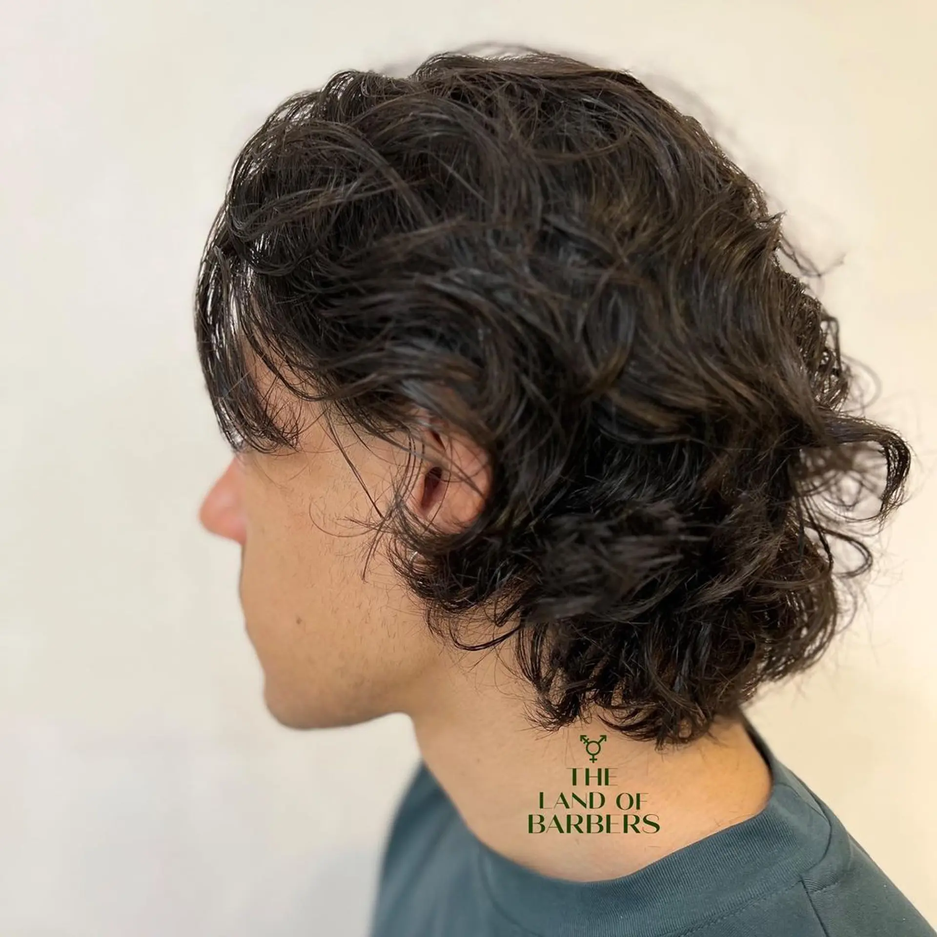 Medium length, wavy dark brown hair with a layered cut. Soft waves frame the face and sides are tucked behind the ears for a relaxed style. 2