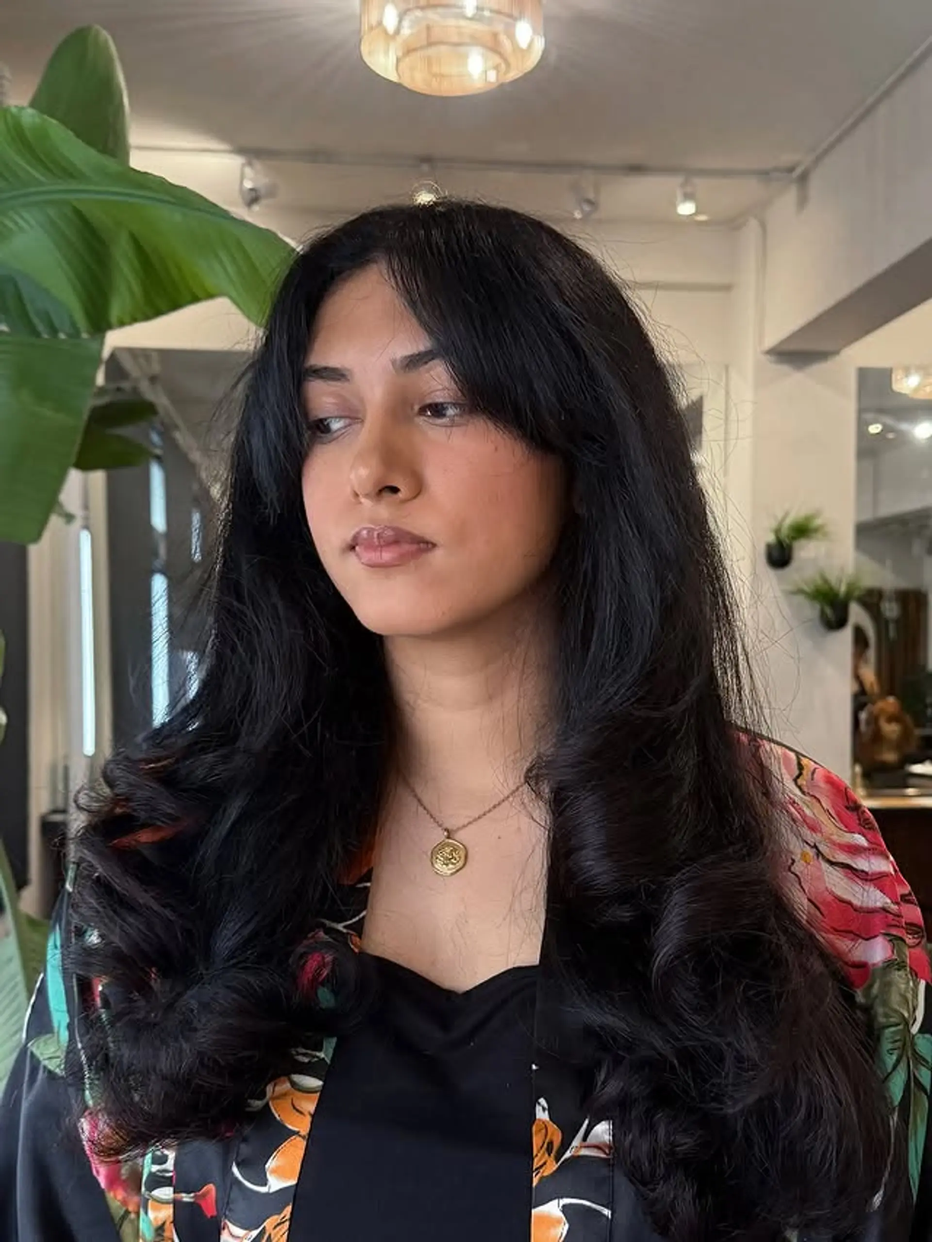 Long wavy hairstyle with curtain bangs and face-framing layers. 1