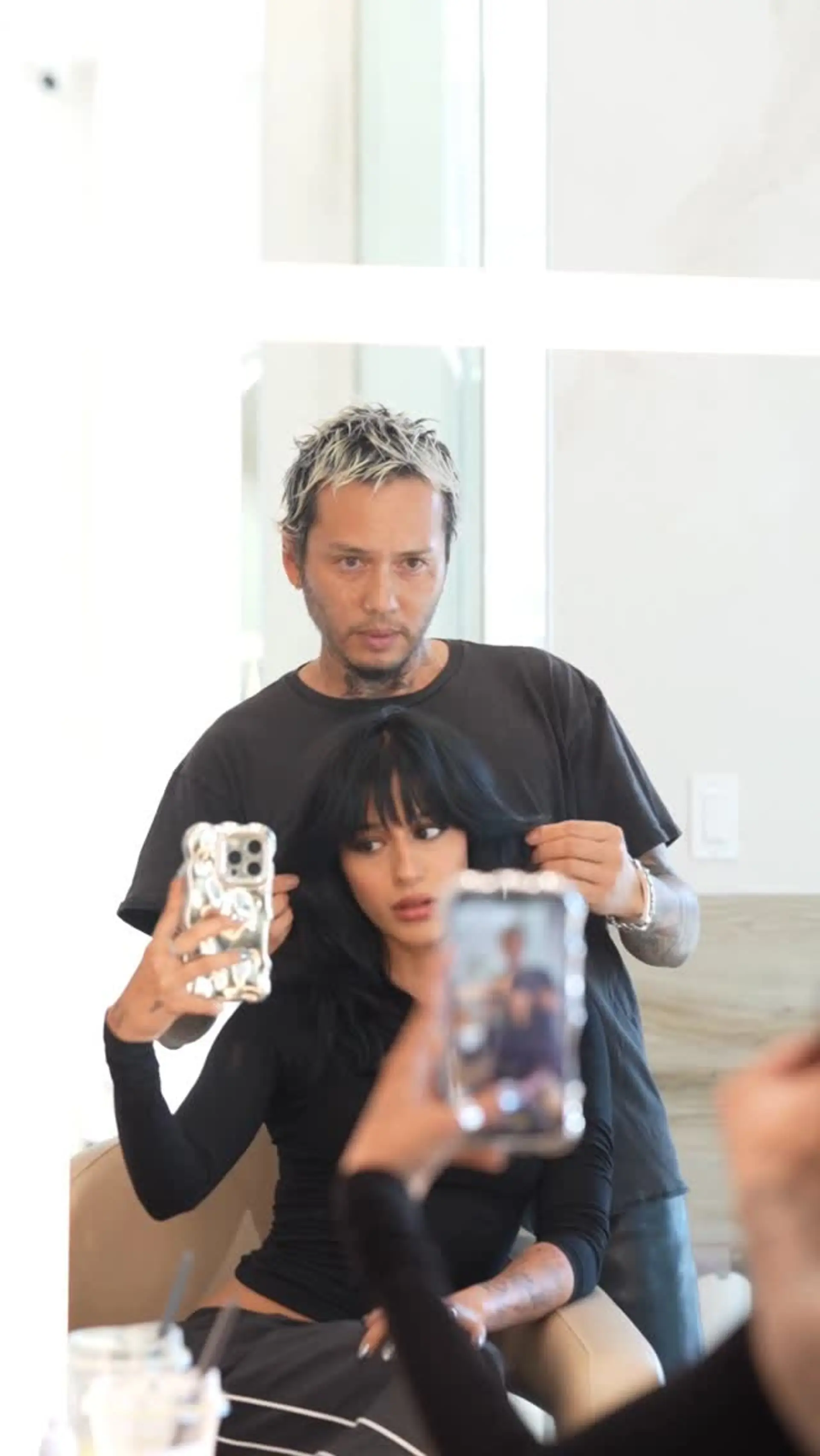 Medium-length layered haircut in jet black with feathered ends and wispy, face-framing bangs. 1