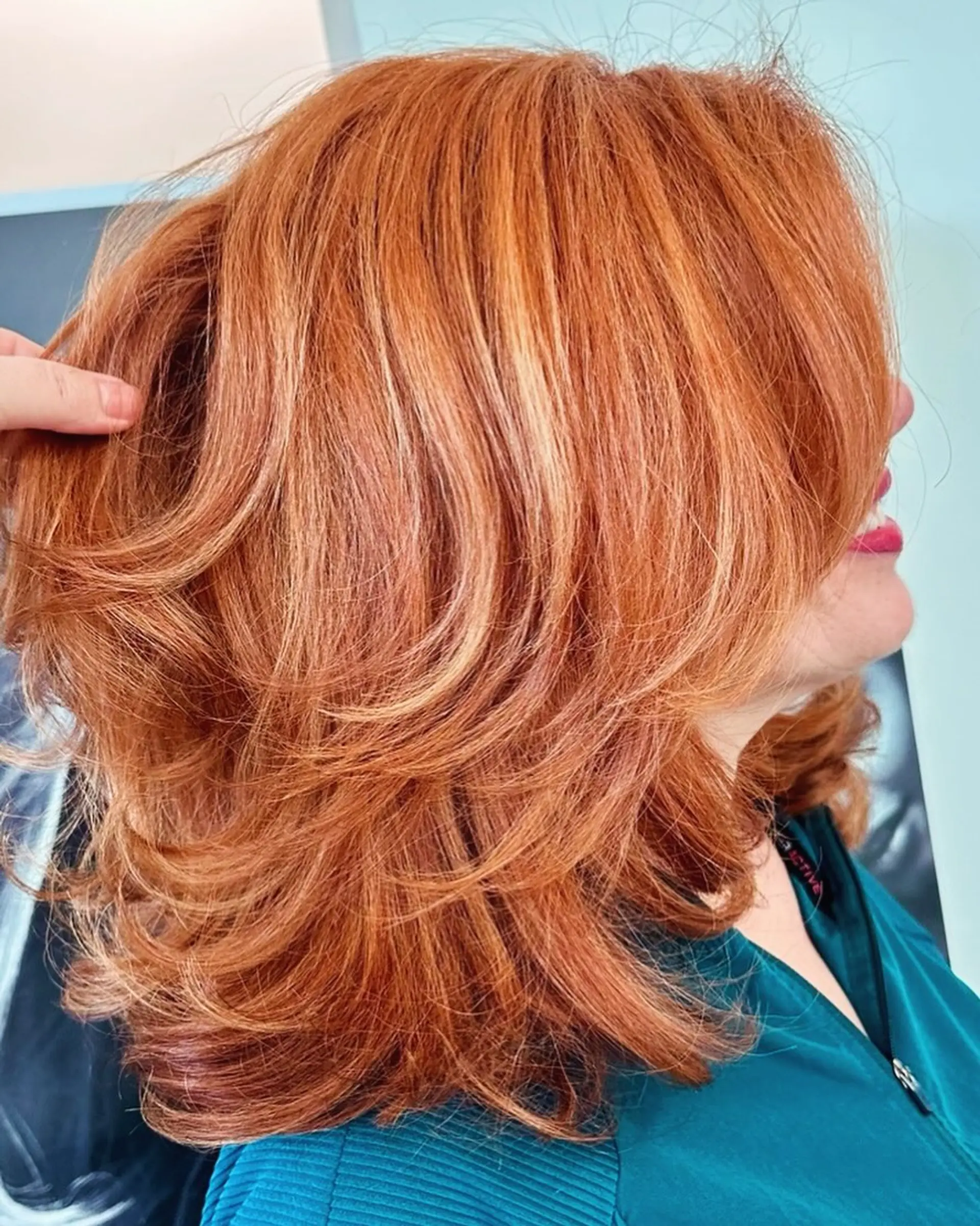 A layered lob with face-framing layers and a copper base with blonde highlights. 1