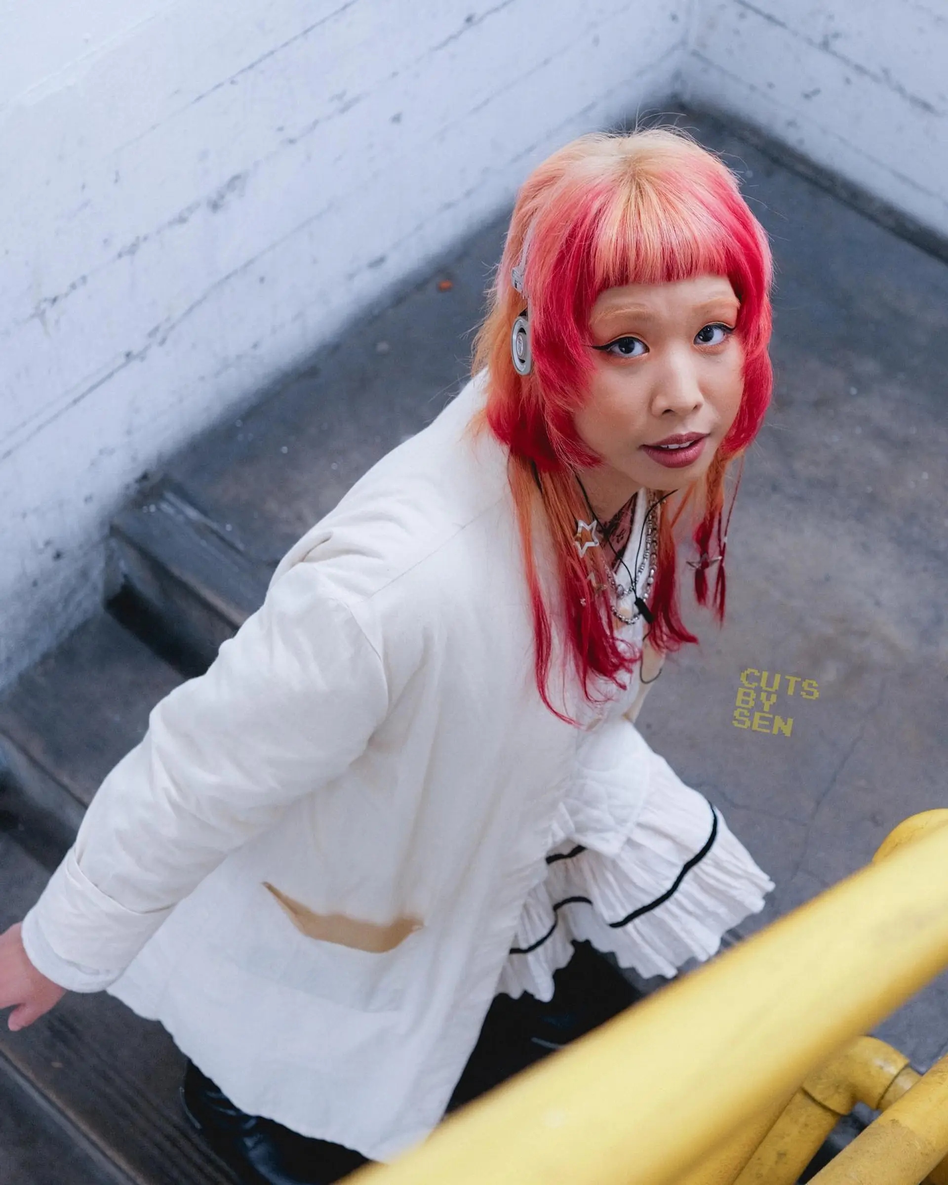 A modern, edgy take on the traditional hime cut featuring micro bangs, face-framing disconnected layers, and vibrant pink and peach tones. 1