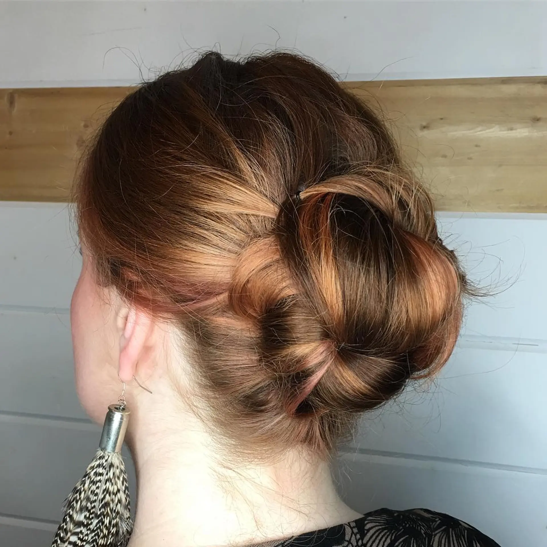 An elegant low bun updo featuring smooth, twisted sections pinned seamlessly at the nape. 1
