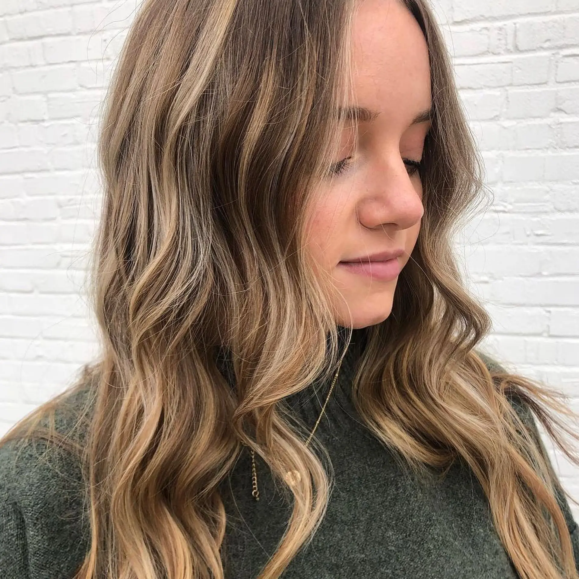A warm honey blonde balayage seamlessly blended into a light brown base and finished with soft, effortless waves. 1