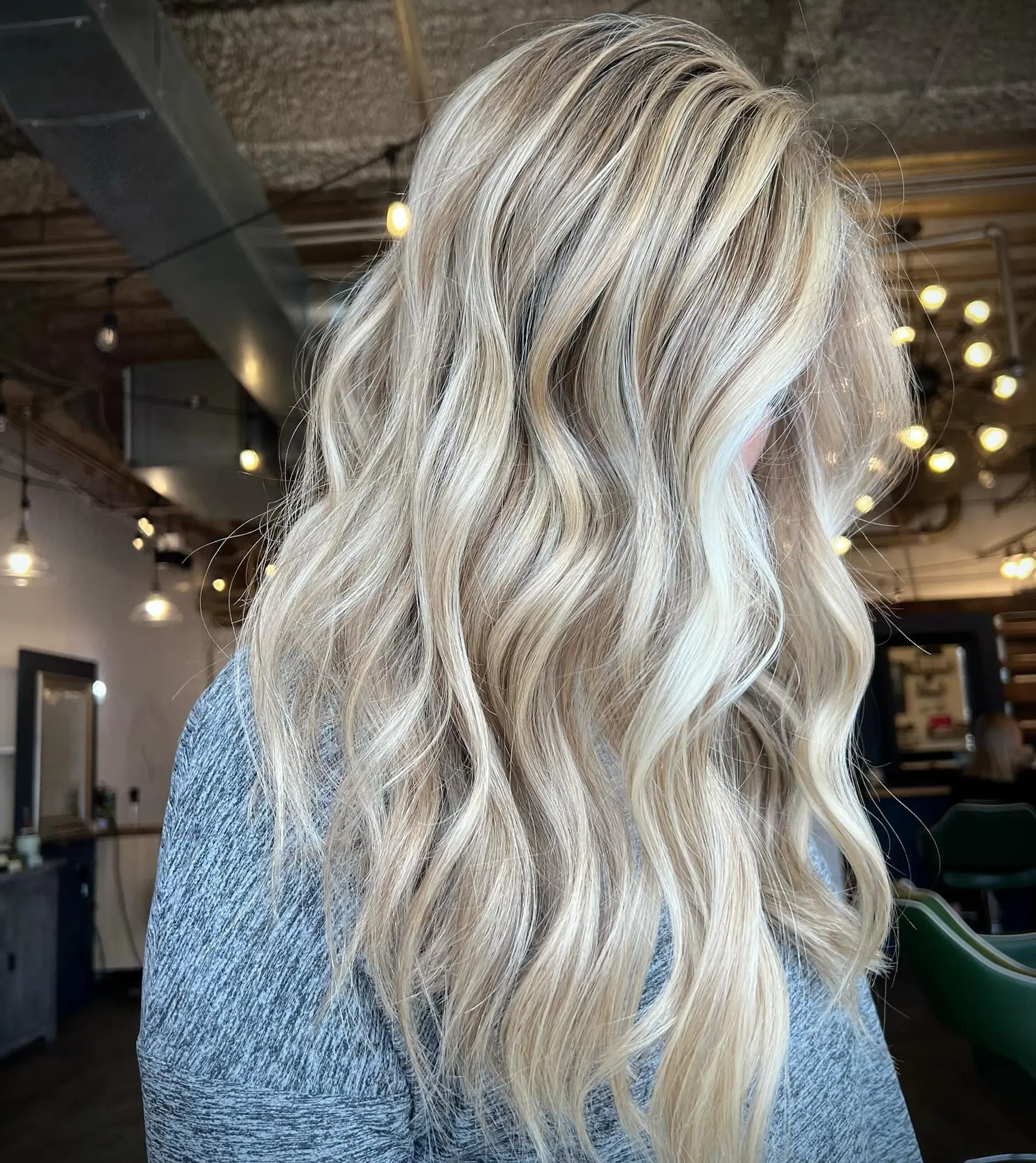 Long dimensional blonde hair styled with soft, loose waves and face-framing brightness. 1