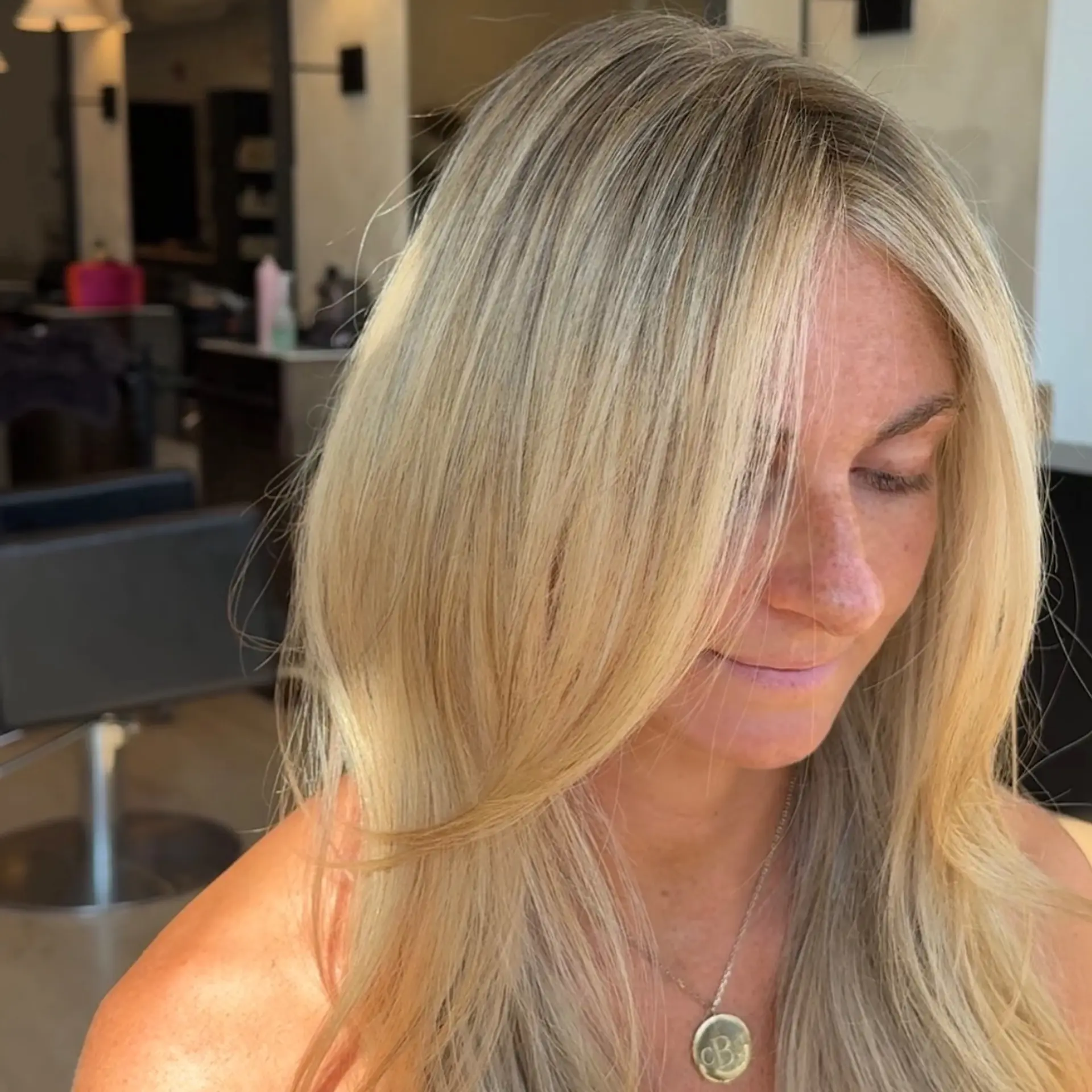 Long, luminous dimensional blonde hair styled with soft, face-framing curtain layers and a smooth blowout. 1