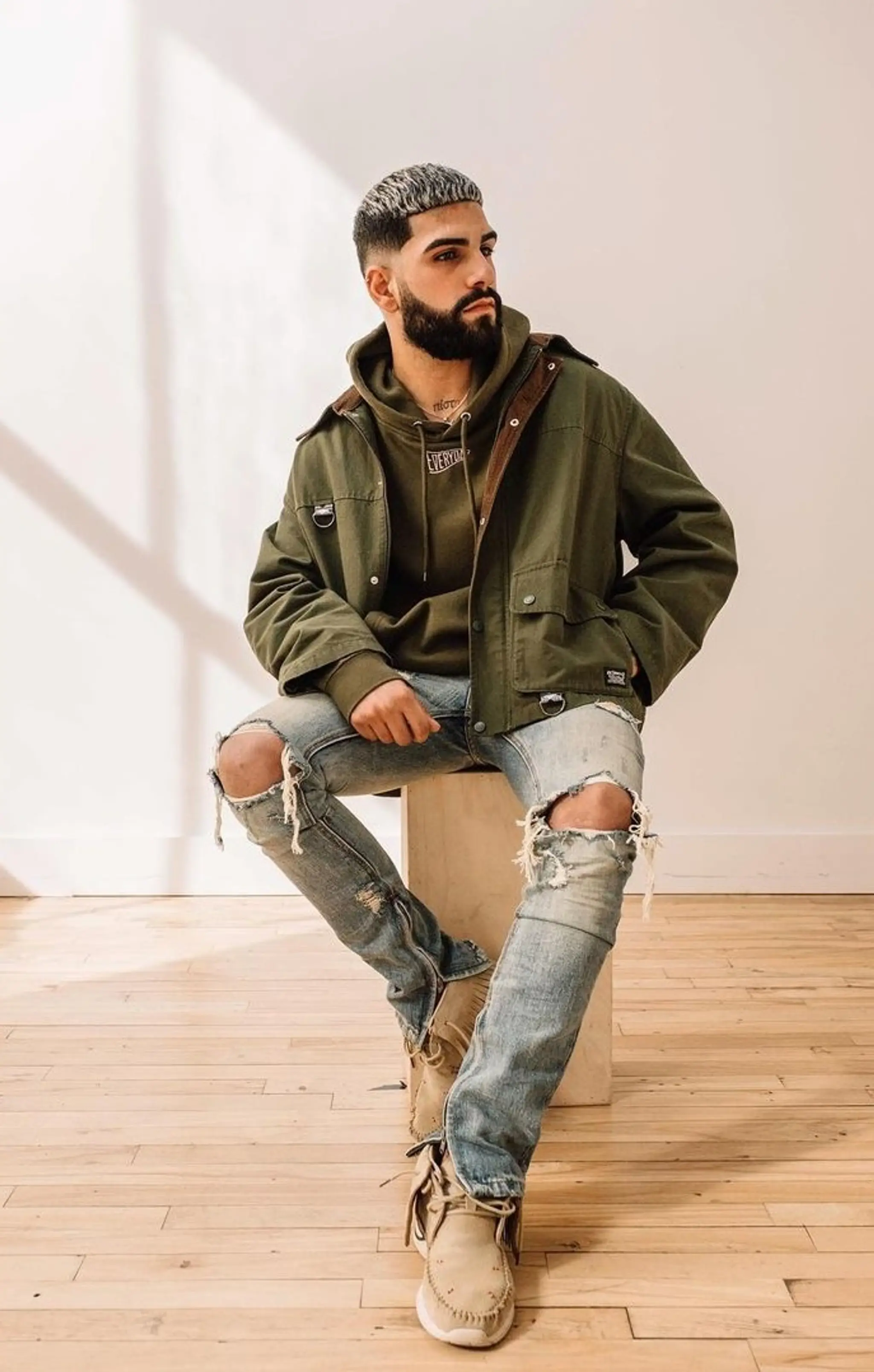 A short buzz cut with tapered edges, featuring gray dye on top creating a frosted contrast against the natural black hair.