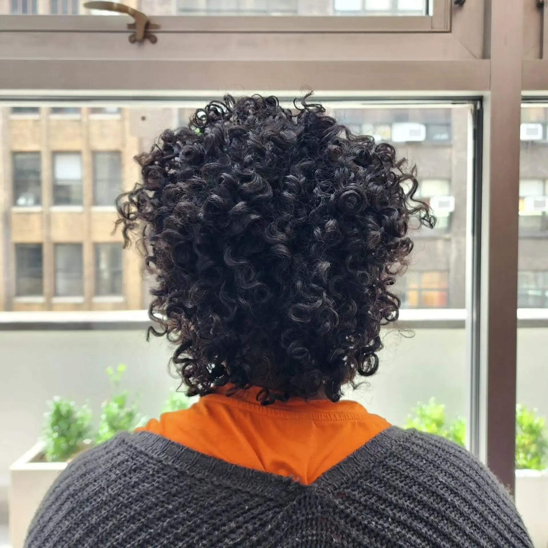 Medium-length, black, curly hair with defined, voluminous curls in a rounded shape, layered for added depth and bounce. 3