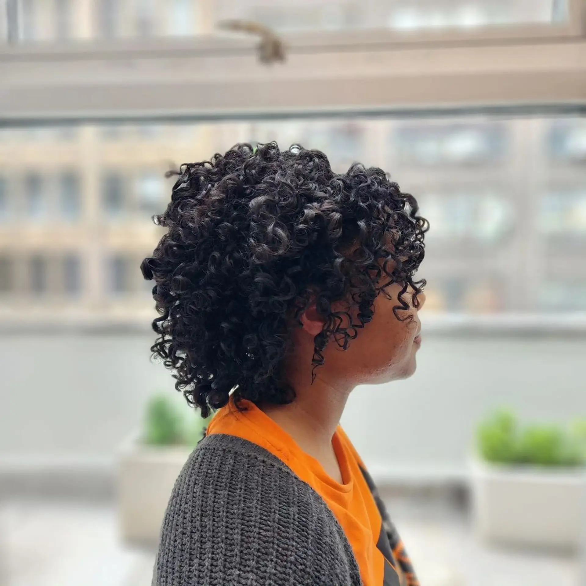 Medium-length, black, curly hair with defined, voluminous curls in a rounded shape, layered for added depth and bounce. 4