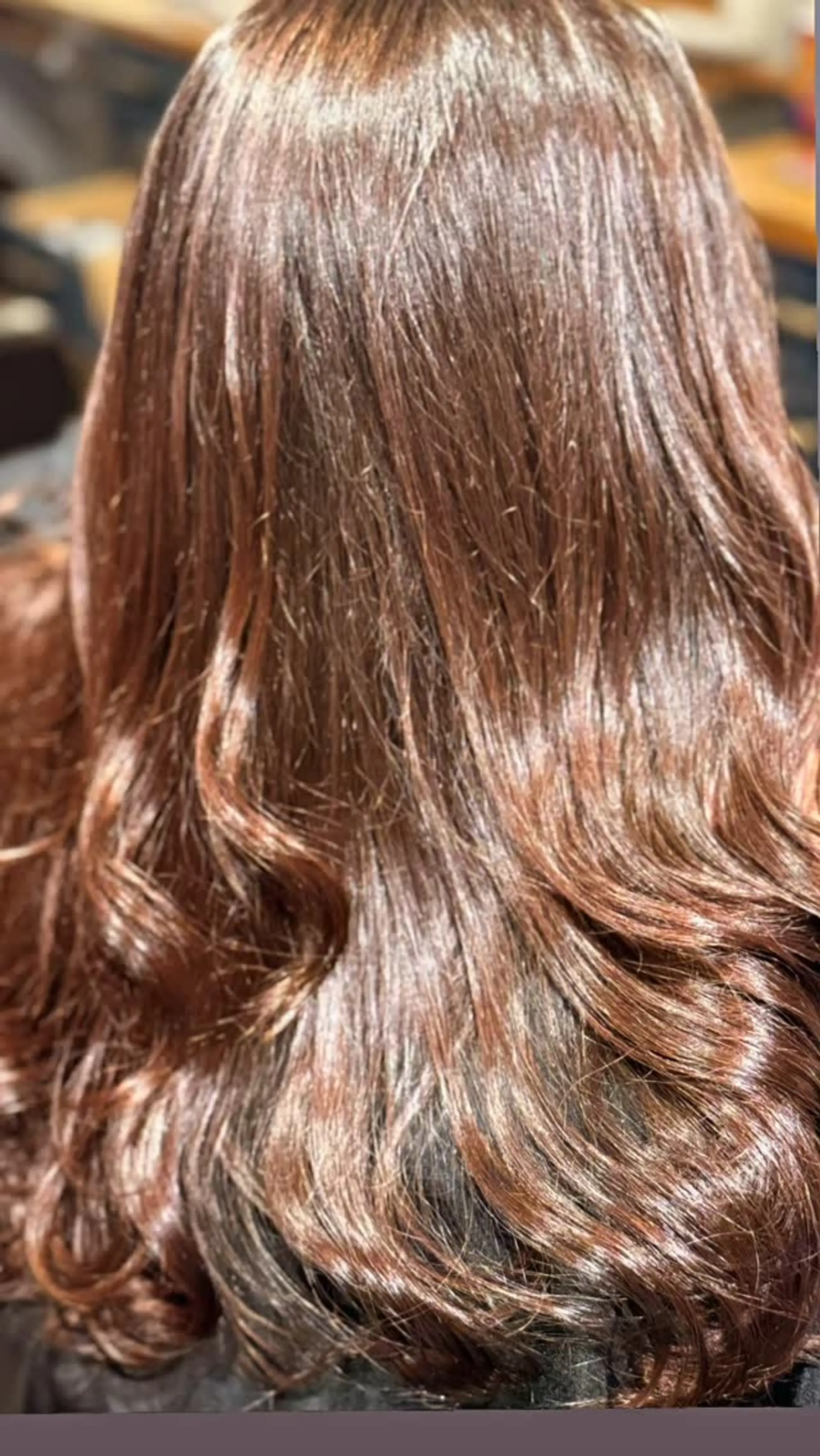 Rich, glossy warm brunette hair styled with a round brush blowout for radiant shine and soft bends at the ends. 1