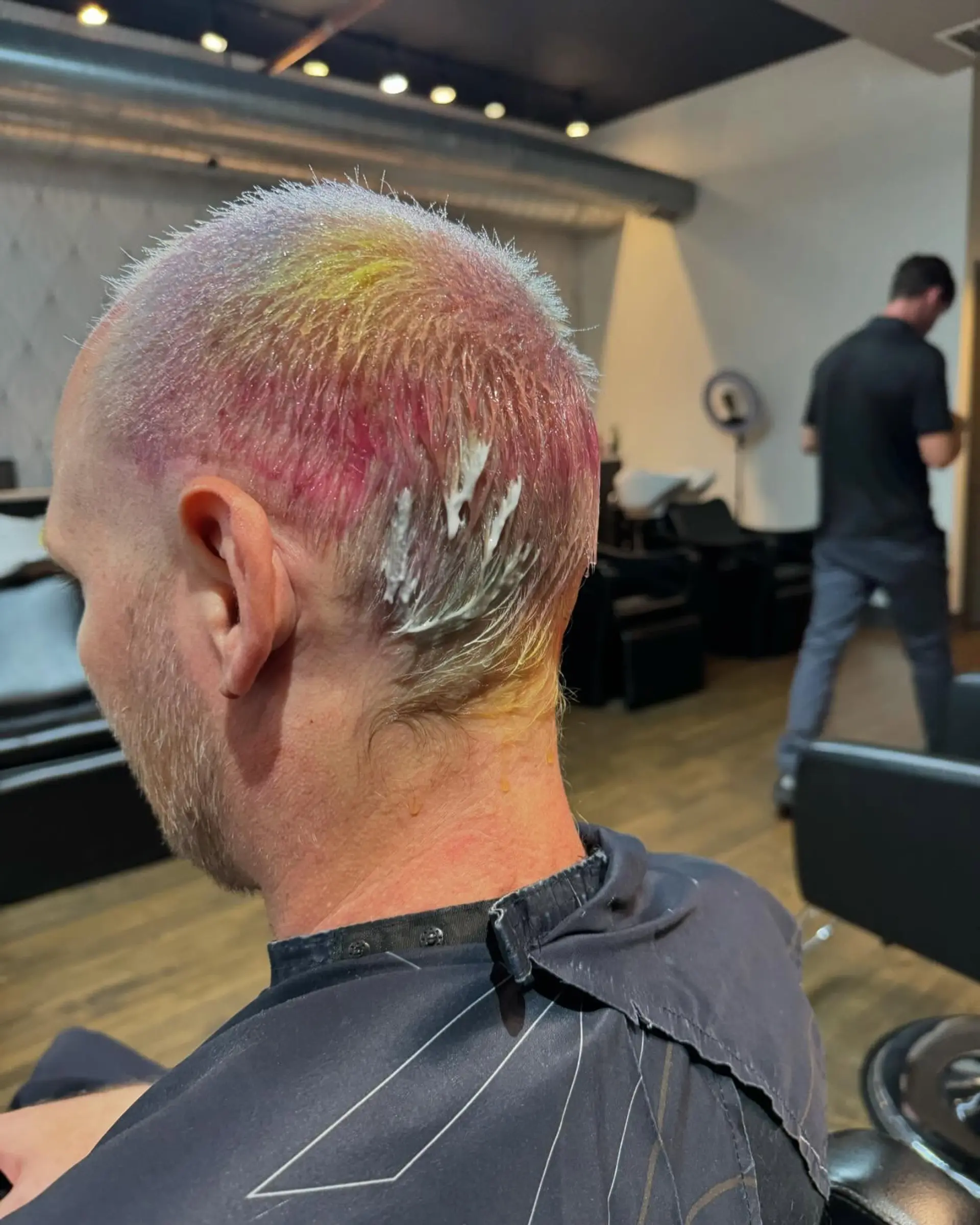 A very short buzz cut with a vibrant rainbow hair color effect. 3