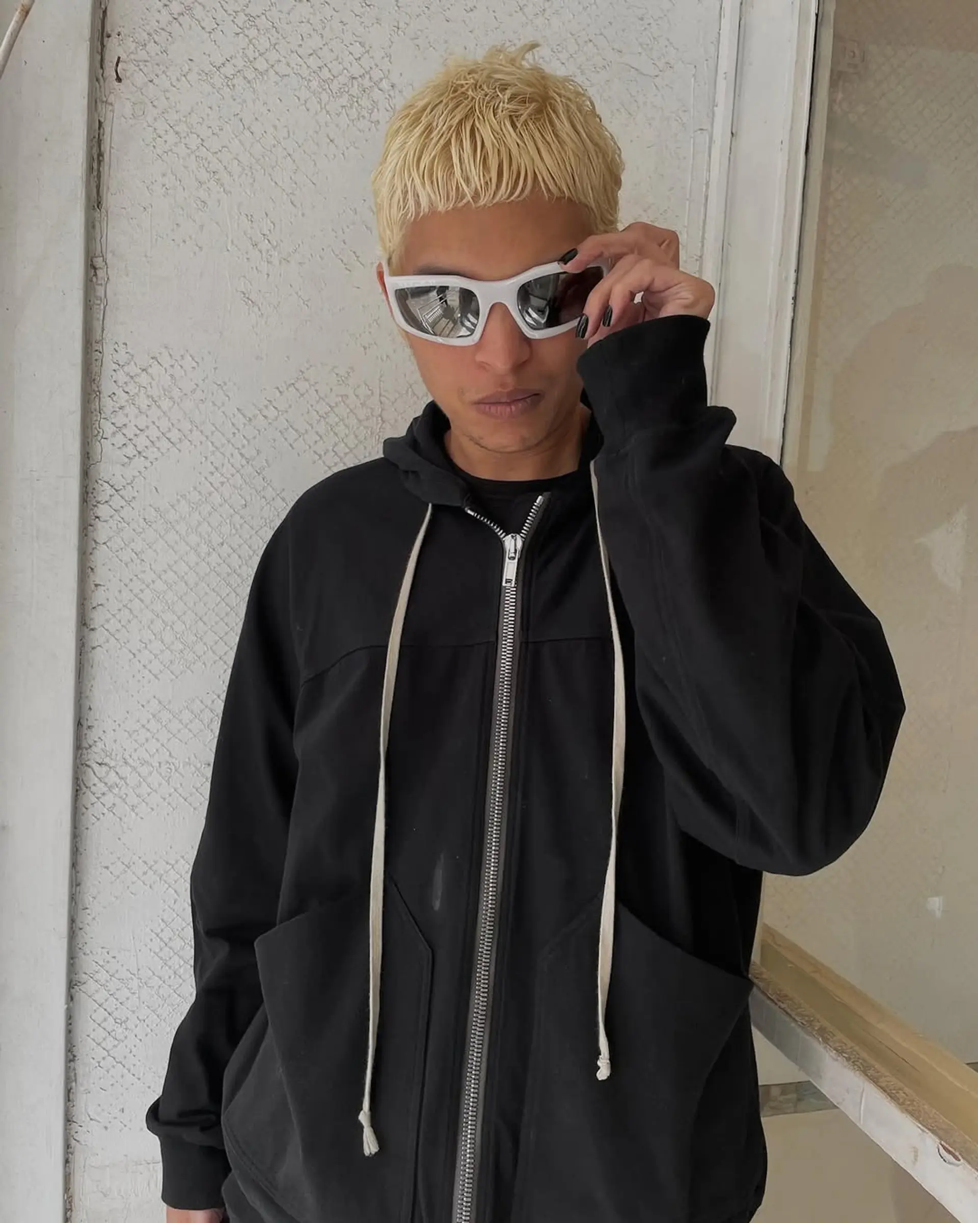 A bold platinum blonde buzz cut with a textured top and undercut, presenting a sleek and edgy appearance. 1