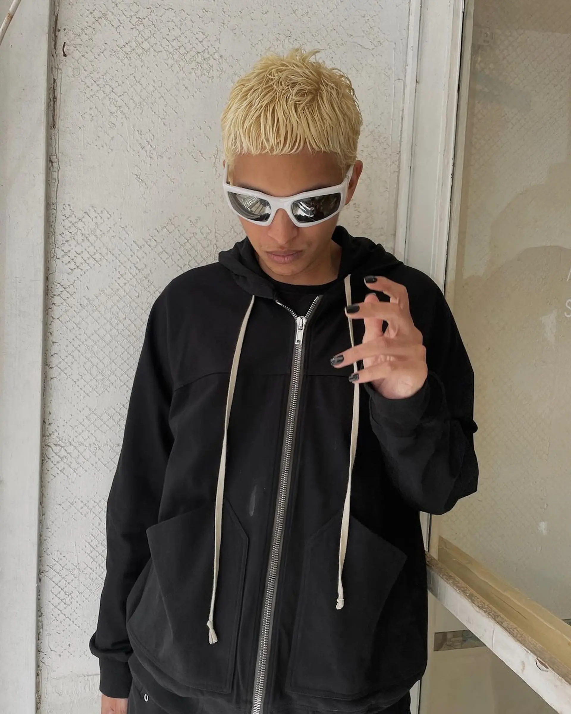 A bold platinum blonde buzz cut with a textured top and undercut, presenting a sleek and edgy appearance. 2