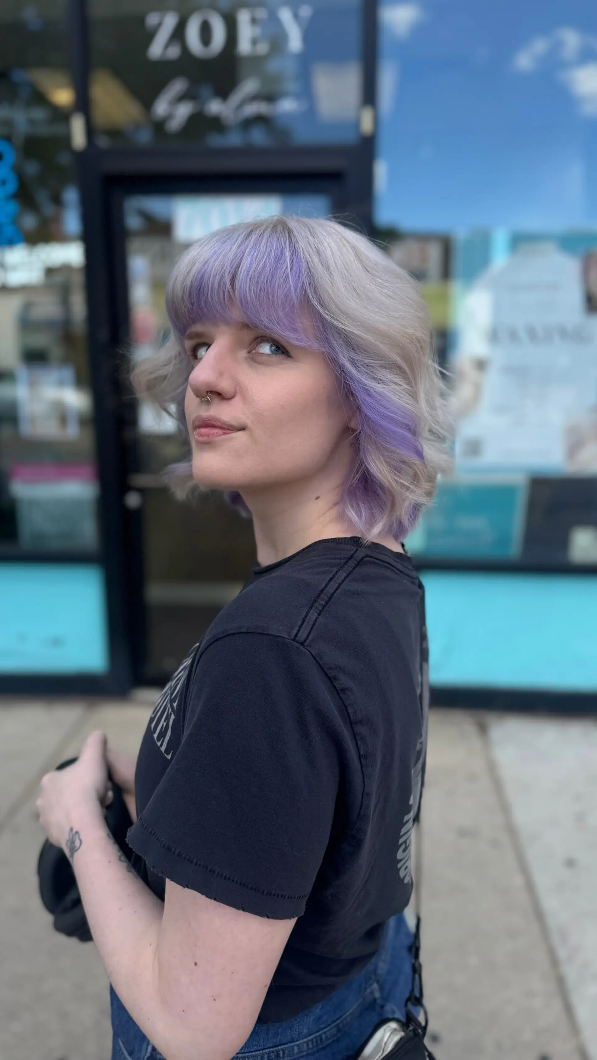 A textured short silver-blonde bob featuring soft waves and lilac peekaboo color through the fringe and sides. 1