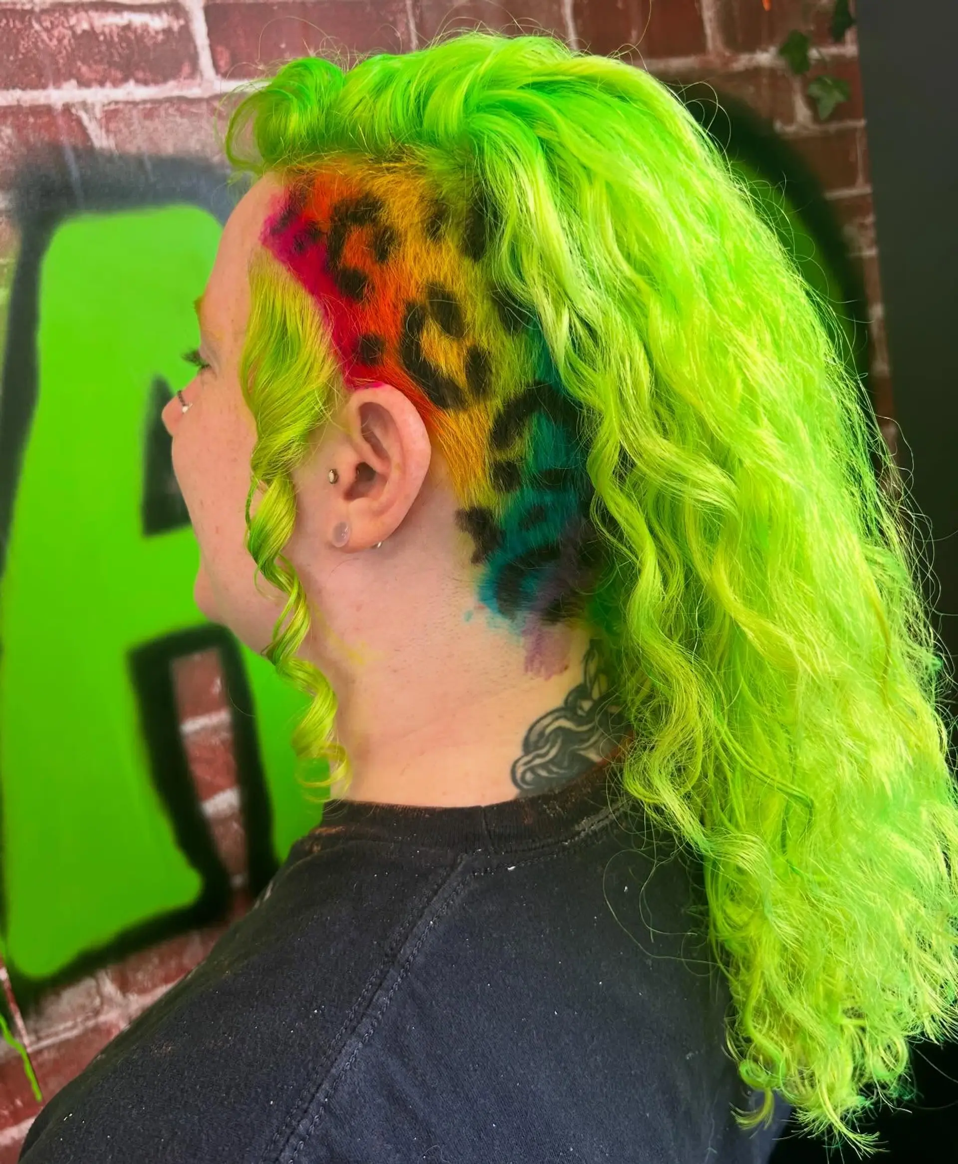 Vibrant neon lime green wavy curls paired with a shaved side panel featuring rainbow-toned leopard spots. 1
