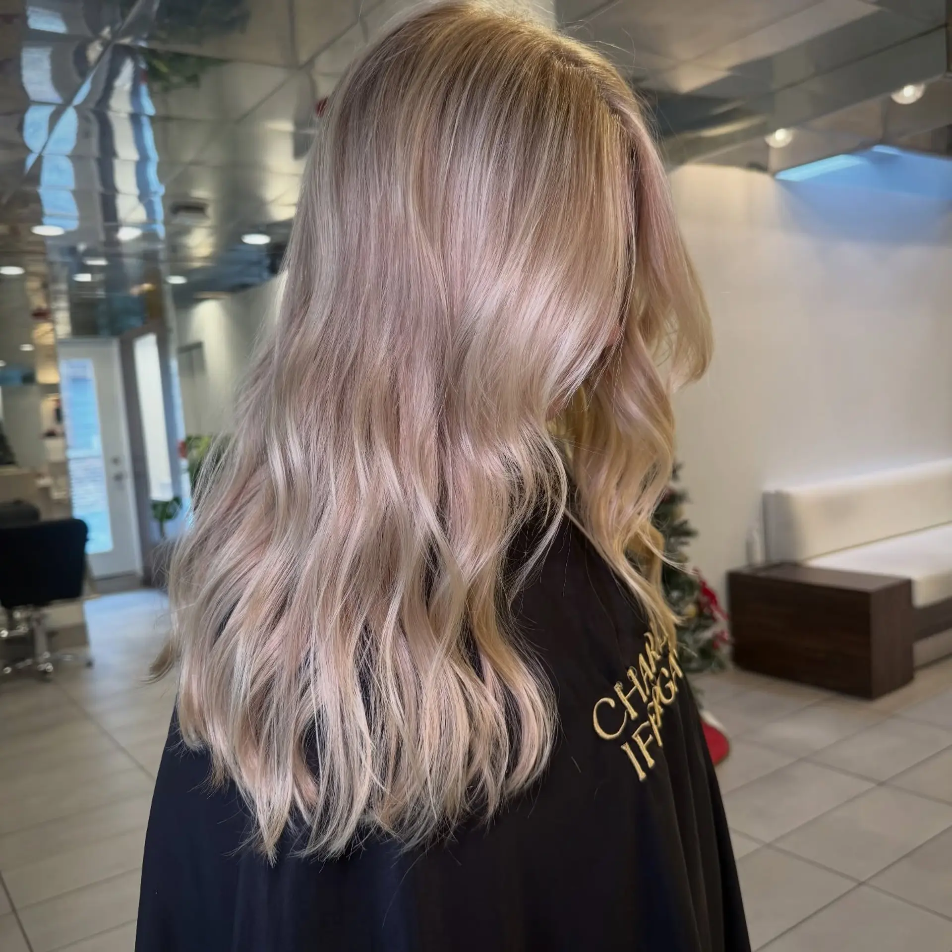 Long ash blonde hair styled into smooth, flowing loose waves with subtle dimensional tone. 1