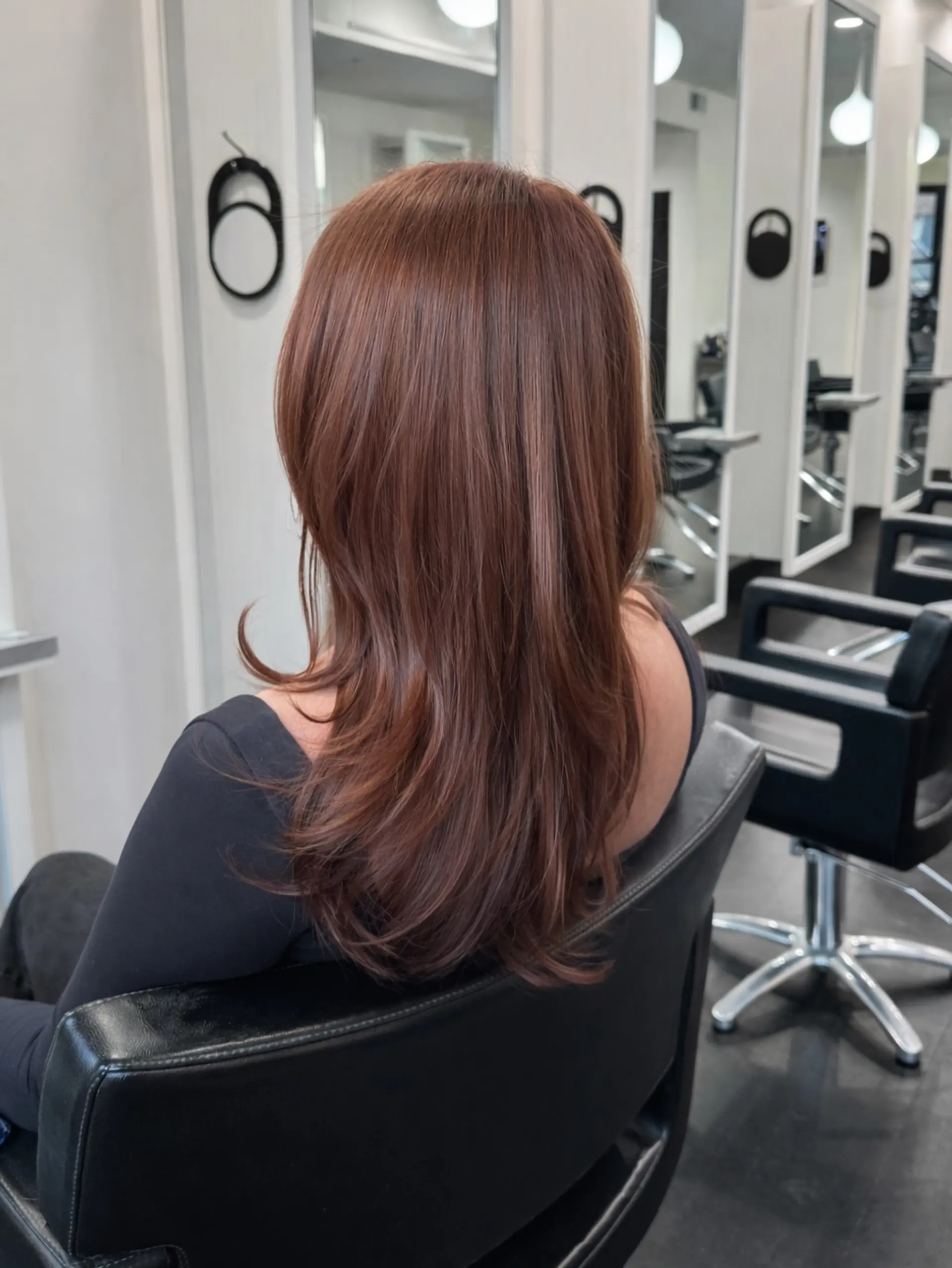 Long layered cowboy copper hair with a smooth blowout and soft outward-curling ends. 1