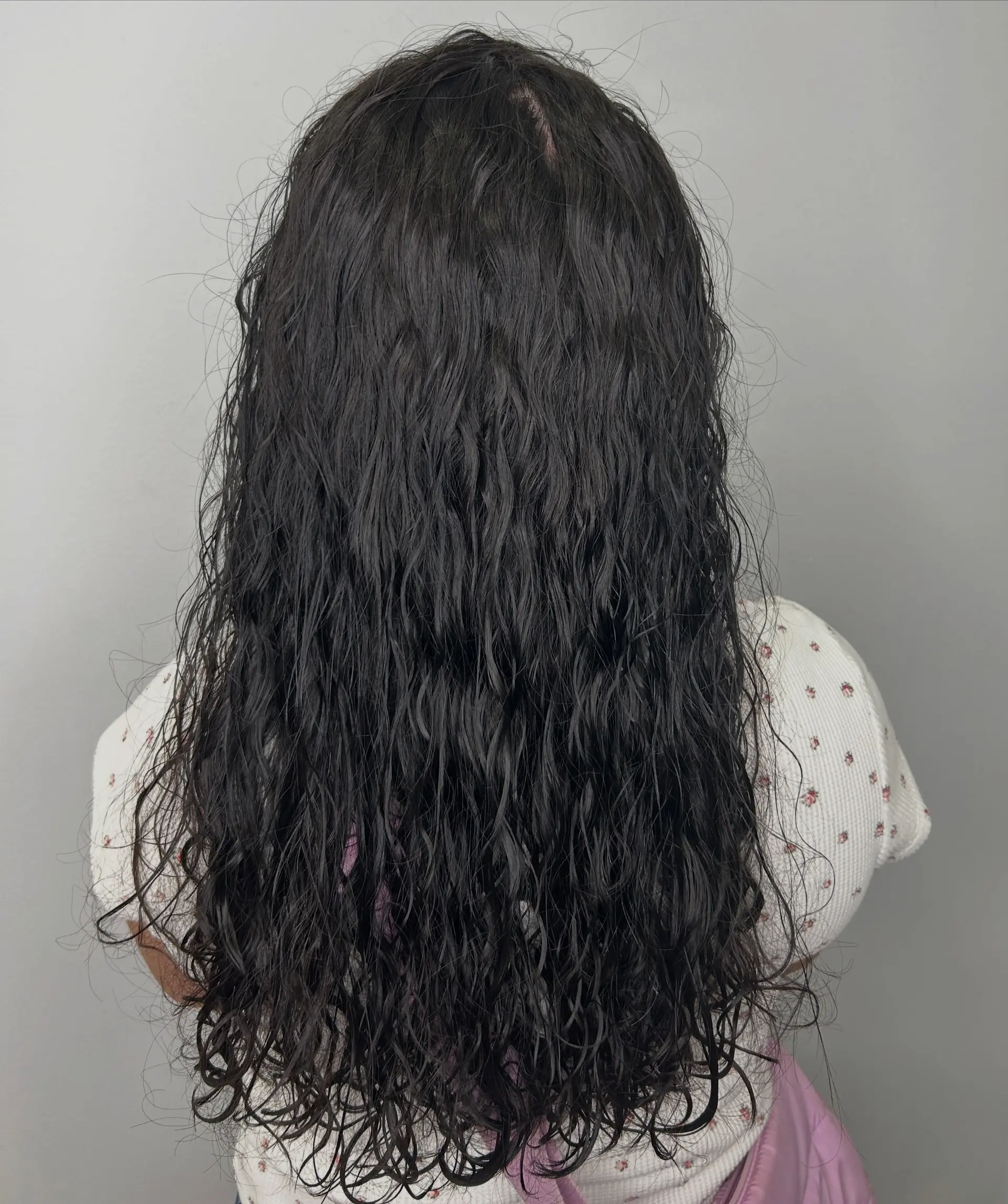 Long dark hair featuring a spiral perm with defined, textured curls and a natural wet-look finish. 1