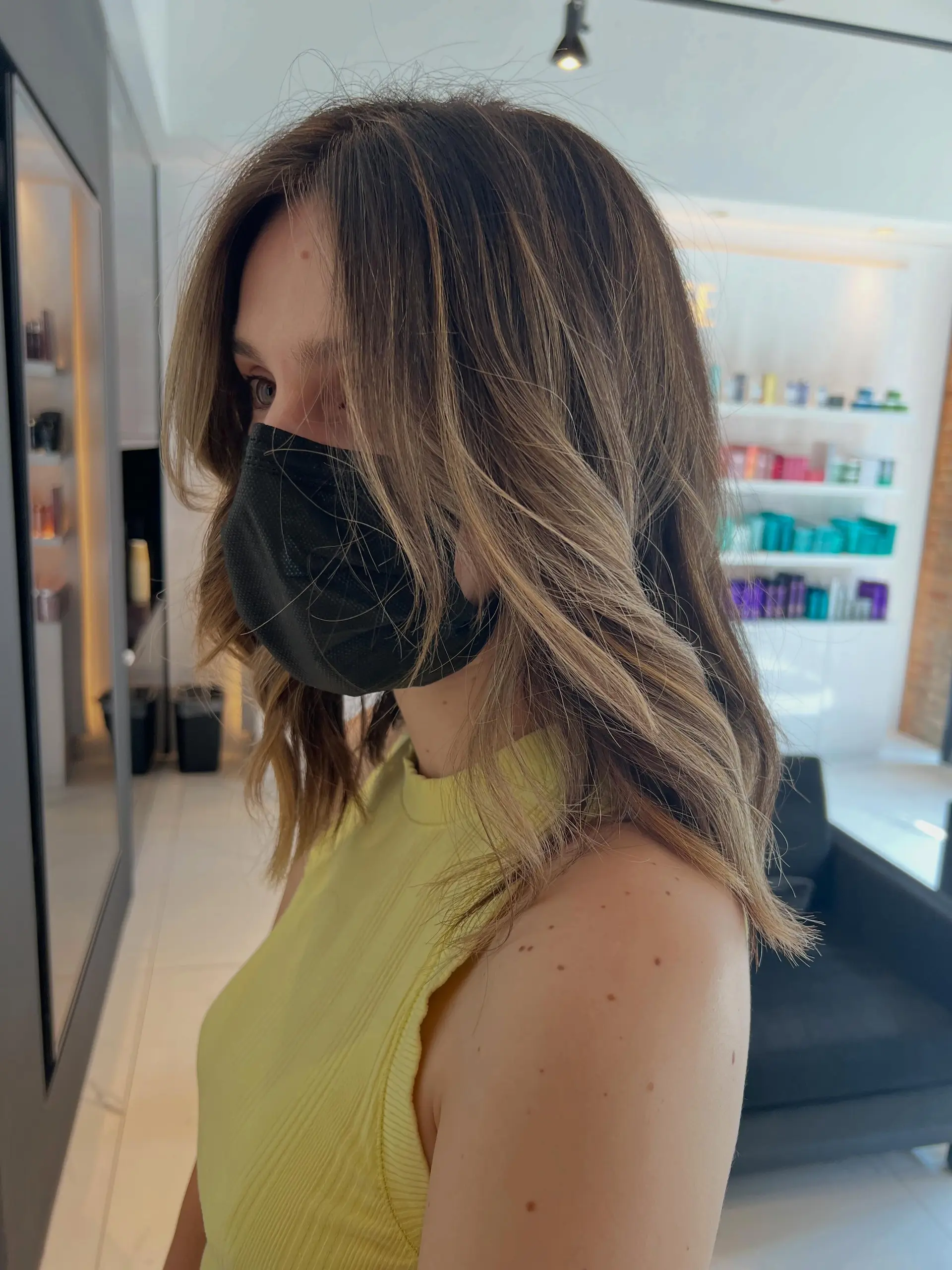 Medium-length brunette hair styled in loose, textured waves with soft, lived-in blonde and light brown balayage highlights. 1